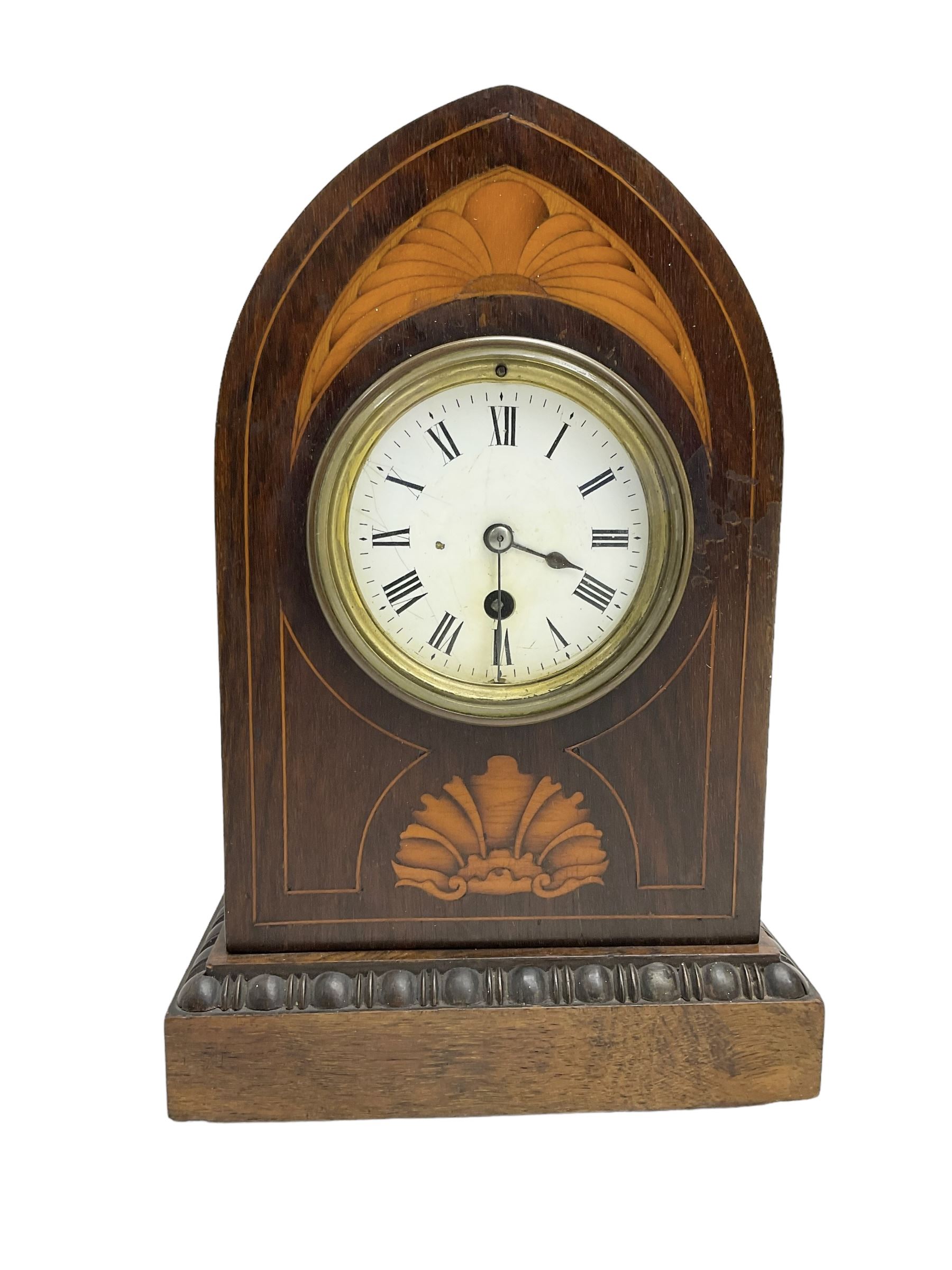 Edwardian - 8-day Rosewood veneered Lancet shaped mantle clock with contrasting inlay and satinwood stringing,  white enamel dial with Roman numerals, minute markers and spade hands, French timepiece movement with pendulum. c1910.