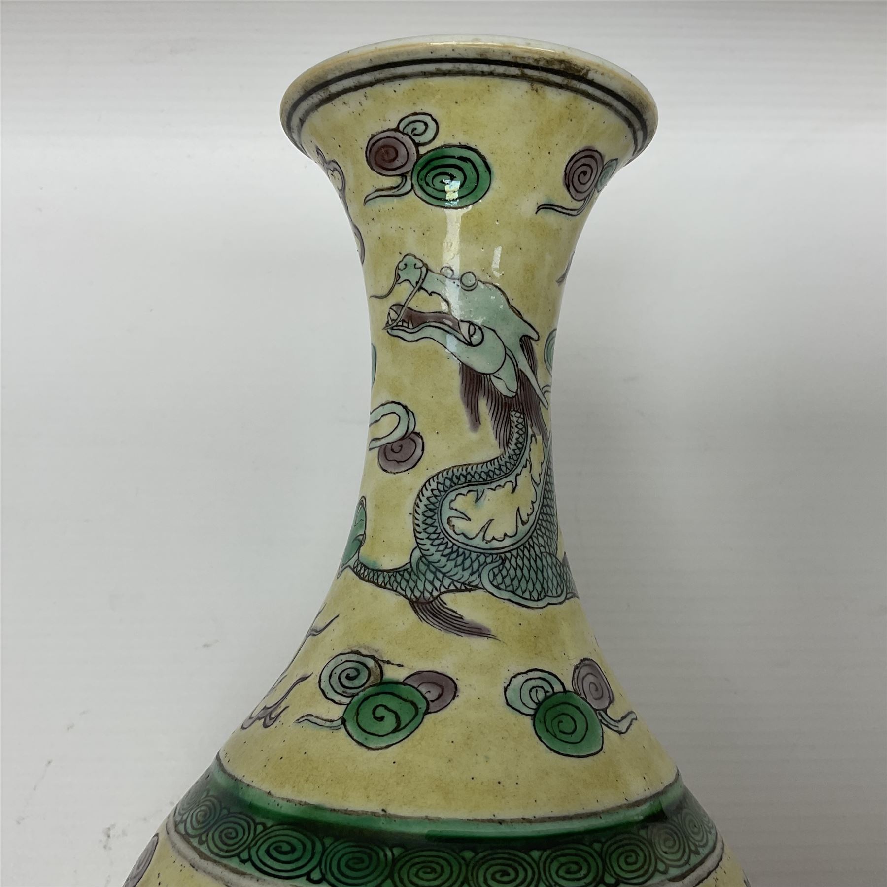 20th century Chinese Famille Verte vase, of slender ovoid form with tapering neck and flared rim, decorated with green and grey enamel with dragons chasing flaming pearls amongst auspicious clouds upon a yellow ground, H30cm