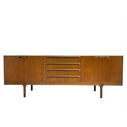 Tom Robertson for AH McIntosh & Co of Kirkaldy - mid-20th century teak sideboard, fitted with four central drawers, flanked by cupboard enclosing shelves and sliding tray, raised on cylindrical supports