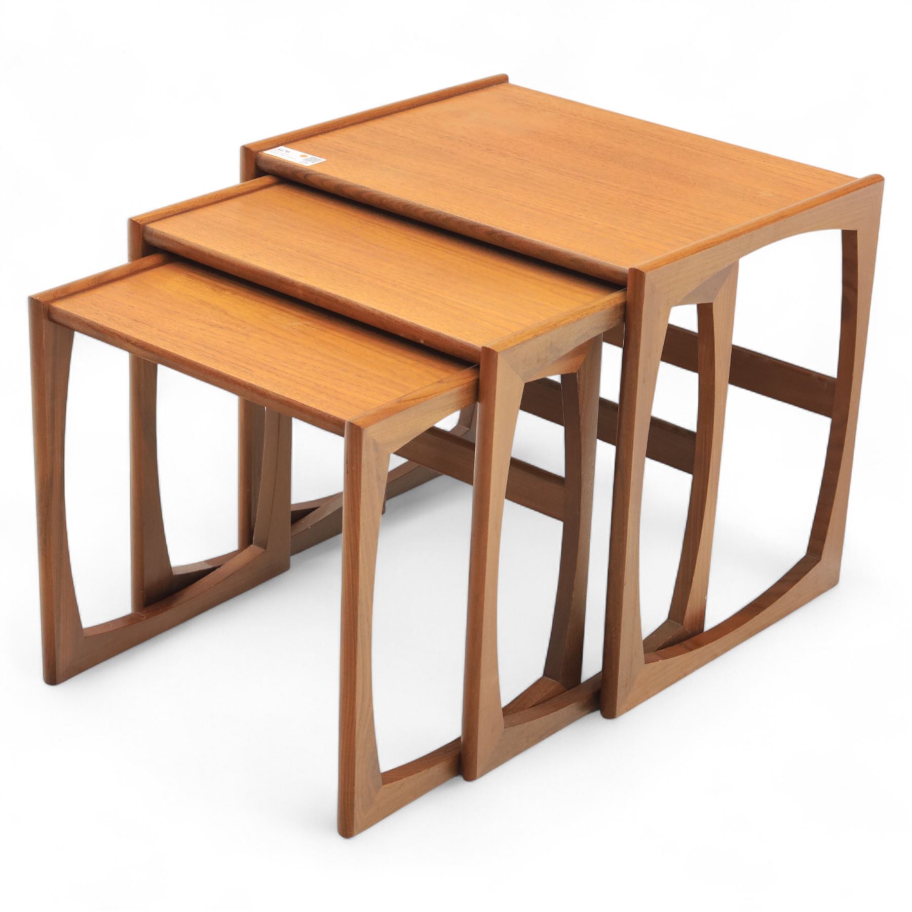 G-Plan - mid 20th century nest of three teak tables, rectangular tops with rounded edges, supported by sculptural open sided frames