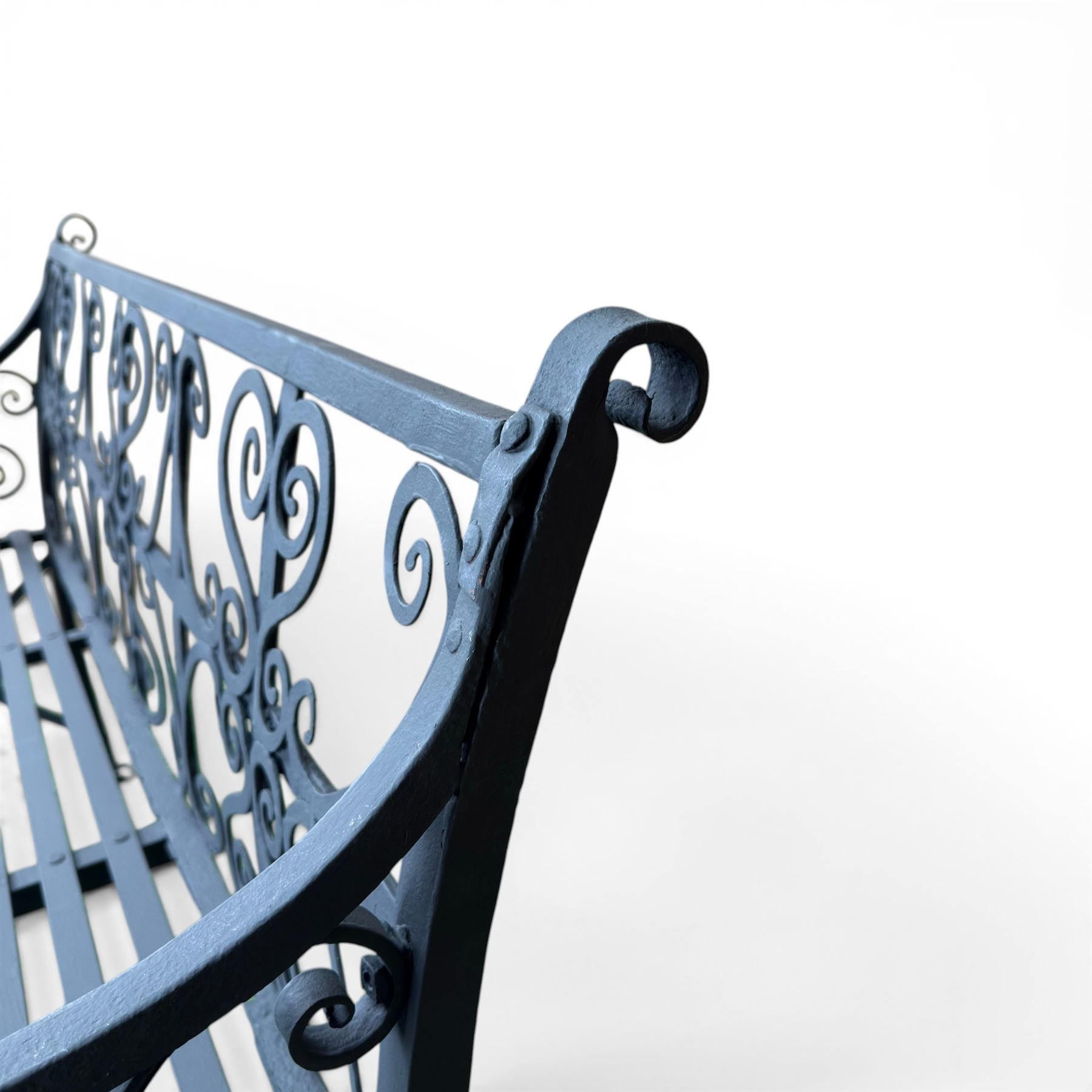 Regency period wrought iron garden bench, hand forged in wrought iron and finished in matt black paint, decorated with intricate scrollwork and featuring circular geometric ends, strapwork seat