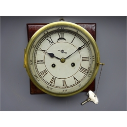  Brass bulkhead clock, painted Roman dial with subsidiary seconds and twin train movement, on mahogany mount board, D25cm max   