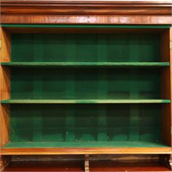 Victorian mahogany cylinder roll-top bookcase-secretaire, projecting cornice over twin glazed doors enclosing two shelves, the cylinder roll-top enclosing fitted interior with sliding drawer, hinged compartments, correspondence drawers and pigeon-holes, the twin pedestals fitted with three graduating drawers to each side, on plinth bases with castors