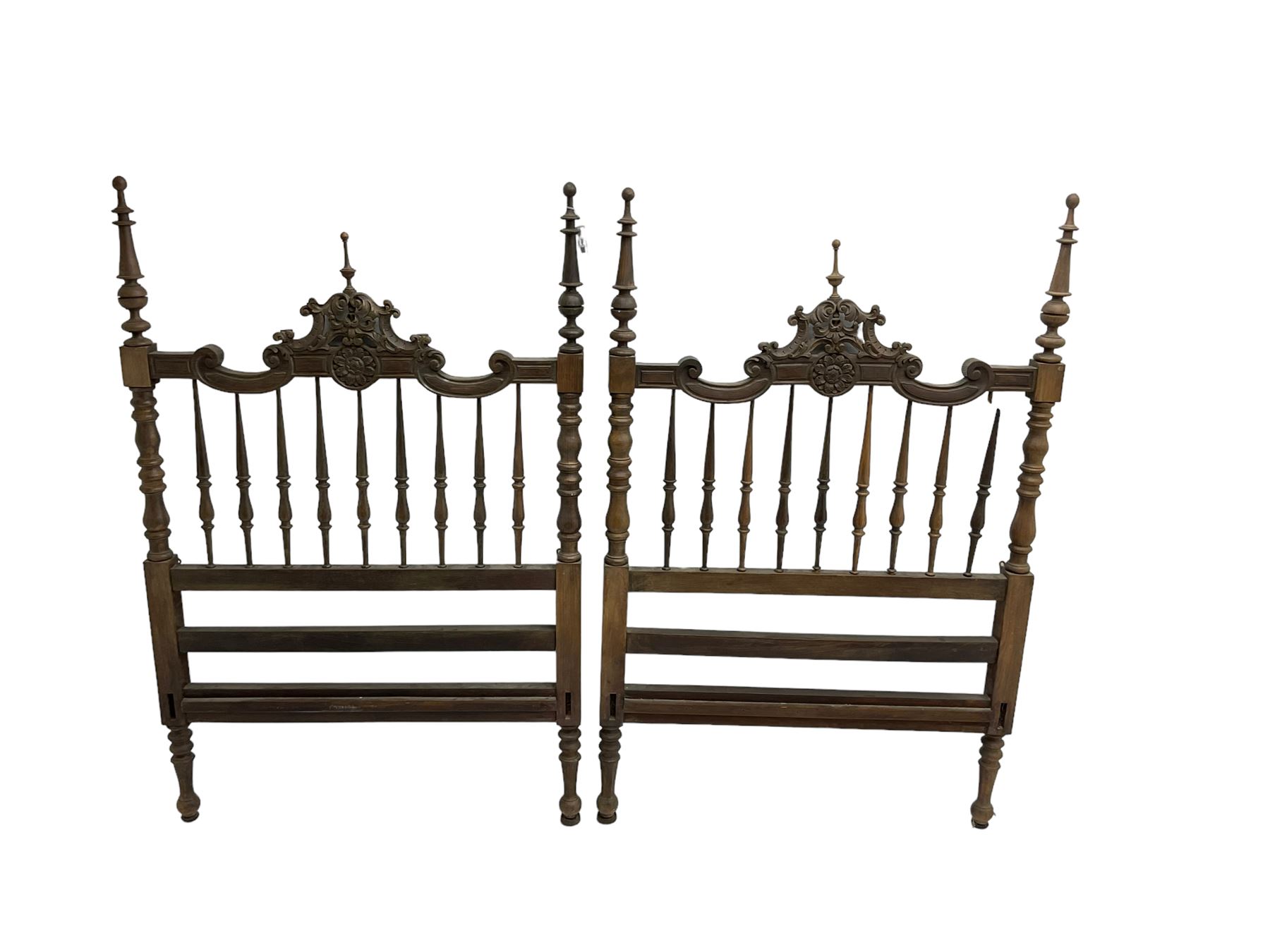 Pair Spanish stained beech single 3' bedsteads, spindle turned backs and carved with scrolling floral decoration 