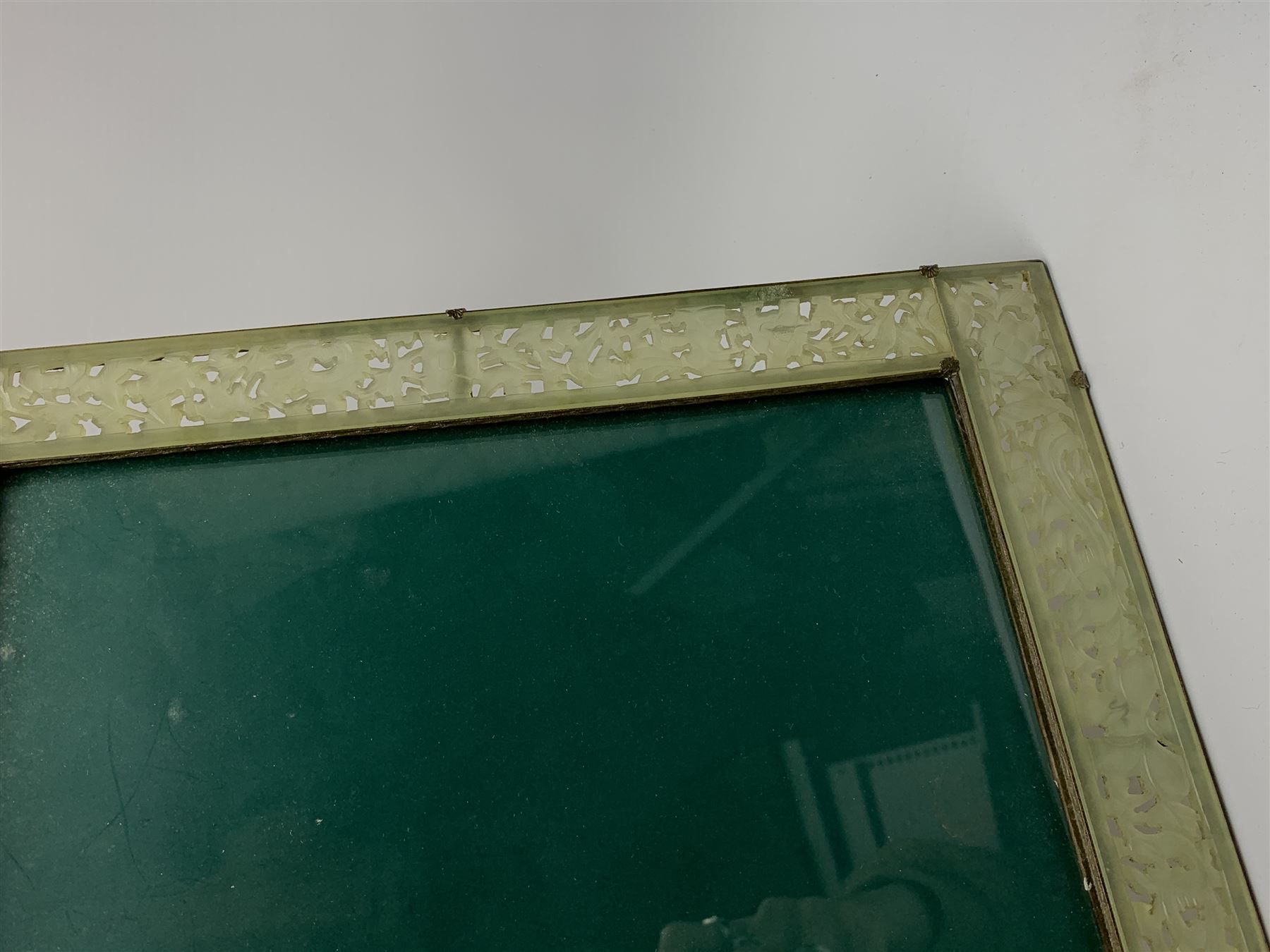 Early 20th century Chinese jade mounted photograph frame, of rectangular form the pierced jade frame carved with flowers and birds, the top panel carved with Foo dogs flaking an applied carved lavender coloured boss, with easel support verso, H33cm

