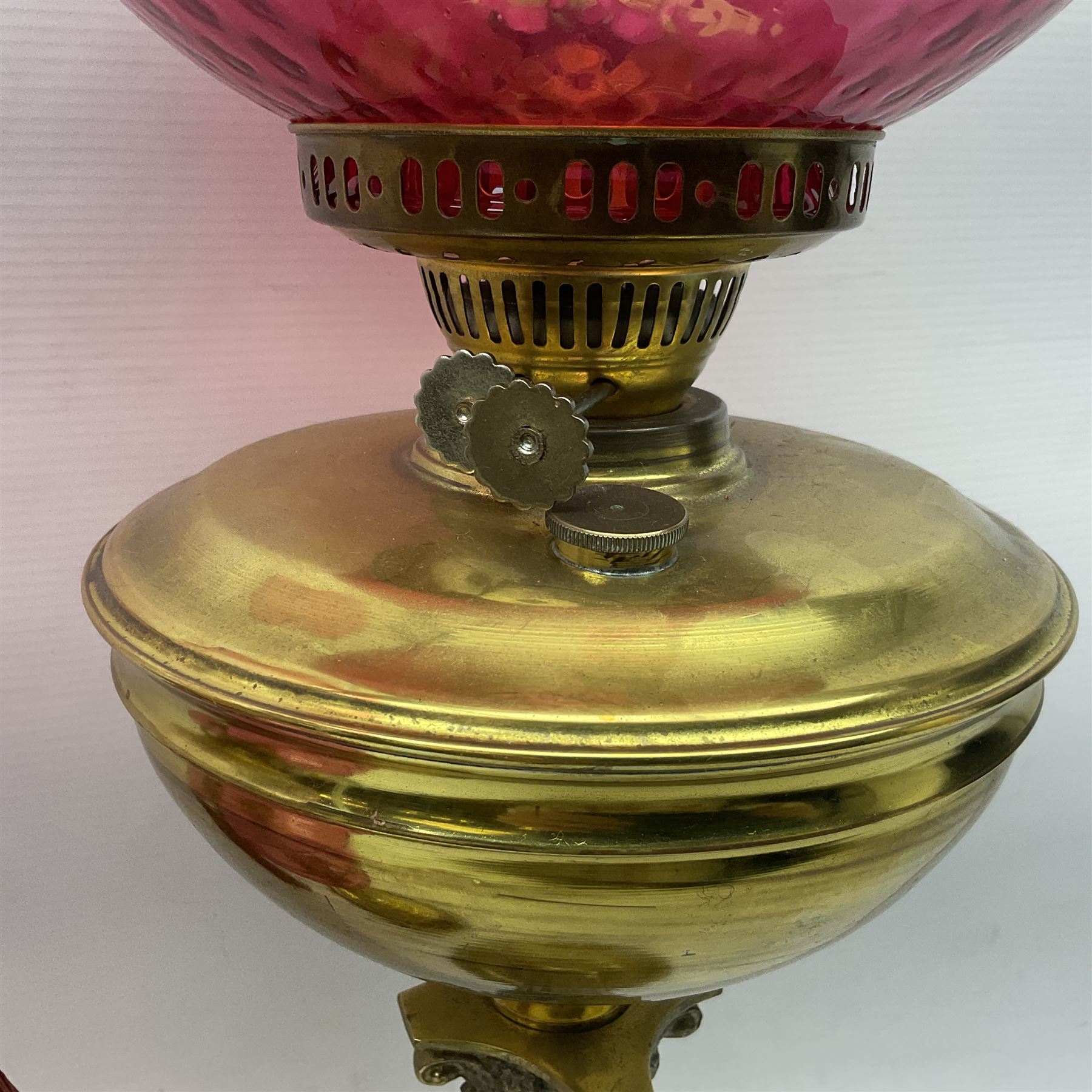 Victorian cast brass oil lamp, with fluted pink glass shade, together with two smaller brass oil lamps with pink shades and reservoirs and a pair of oil lamps, the bases modelled as putti, with pink glass reservoir  and frosted shades, tallest H70cm
