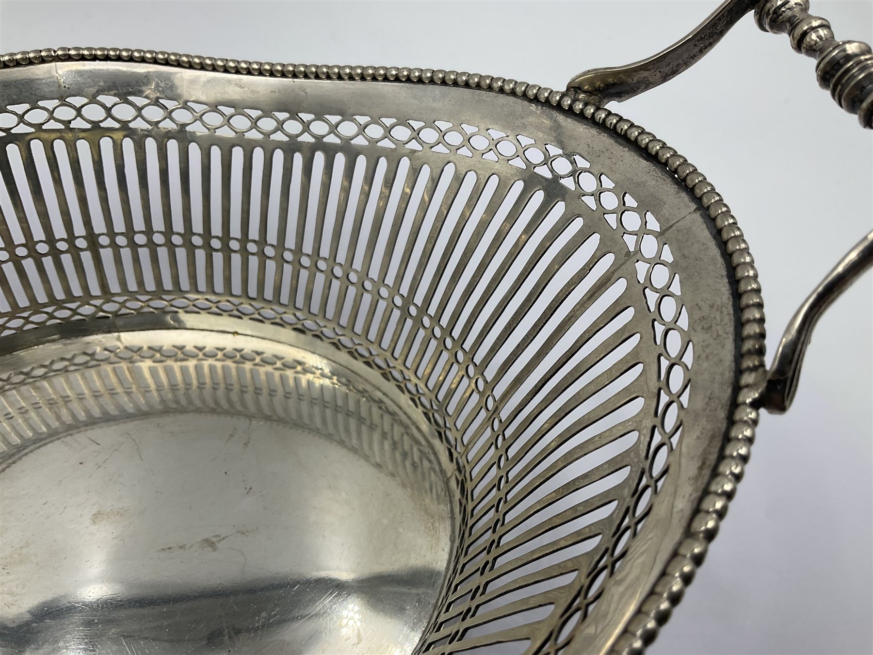 Early 20th century Dutch silver basket, of oval form with pierced sides, beaded rim, and twin handles, marked with Lion Passant for 2nd standard purity and date letter for 1910, other marks worn and indistinct, including handles H8.5cm L25.5cm
