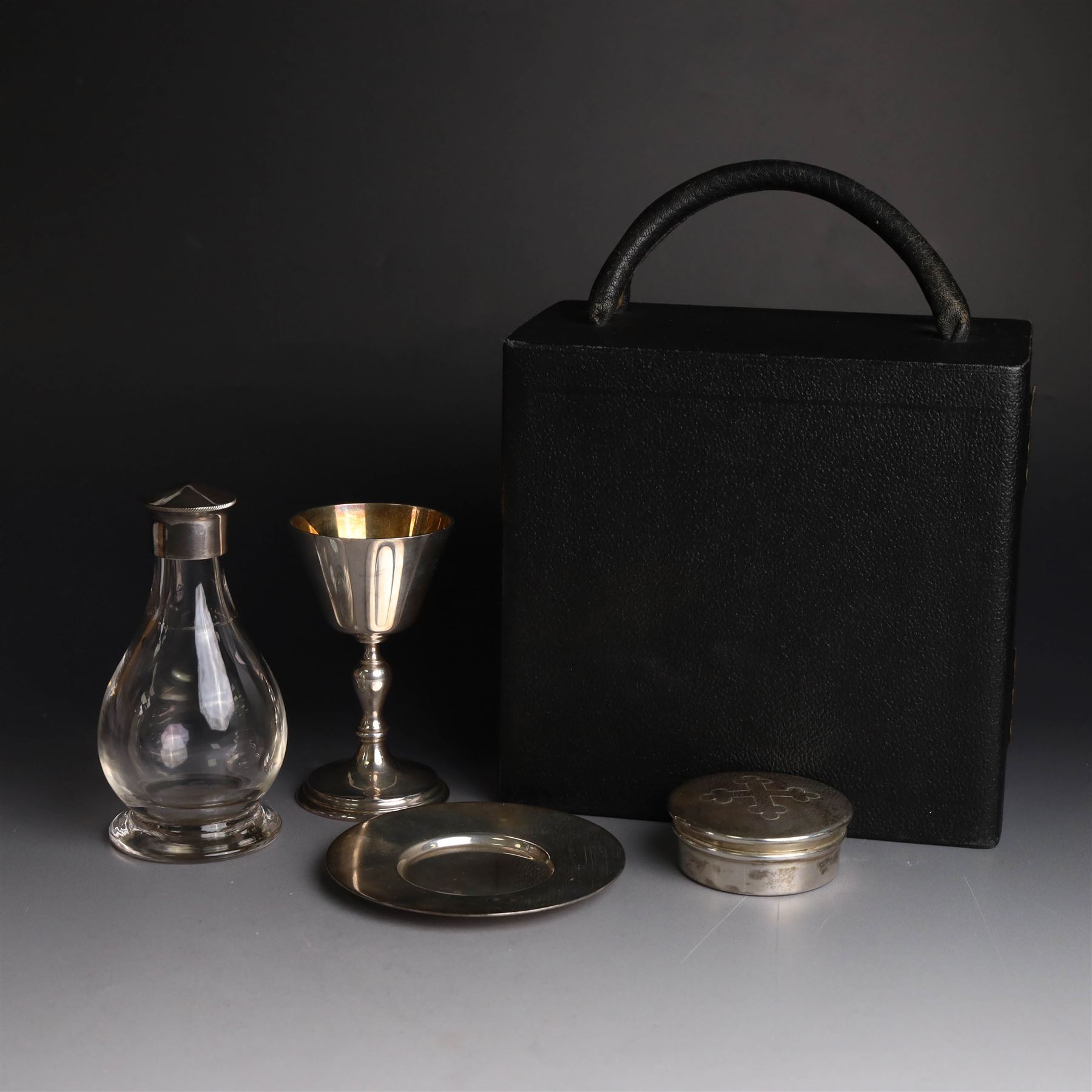 Mid 20th century silver travelling communion set, comprising goblet, paten and pyx, all hallmarked Hurst, Franklin & Co Ltd, London 1961 & 1962, with a glass bottle with unmarked cover, all within a tooled leather fitted case, goblet H9cm