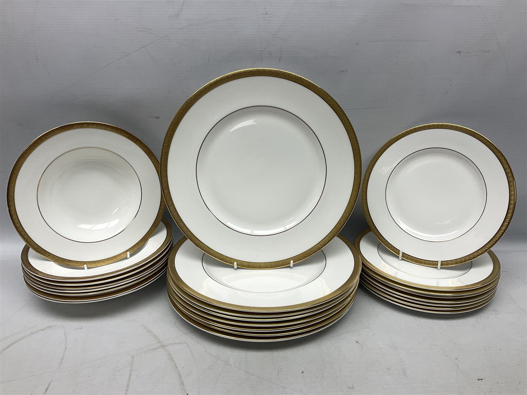 Royal Doulton Royal Gold pattern tea and dinner service for eight, comprising dinner plates, side plates, tea plates, soup bowls, sauce boat and saucer, dessert bowls, coffee cans and saucers, teacups and saucers and two lidded tureens