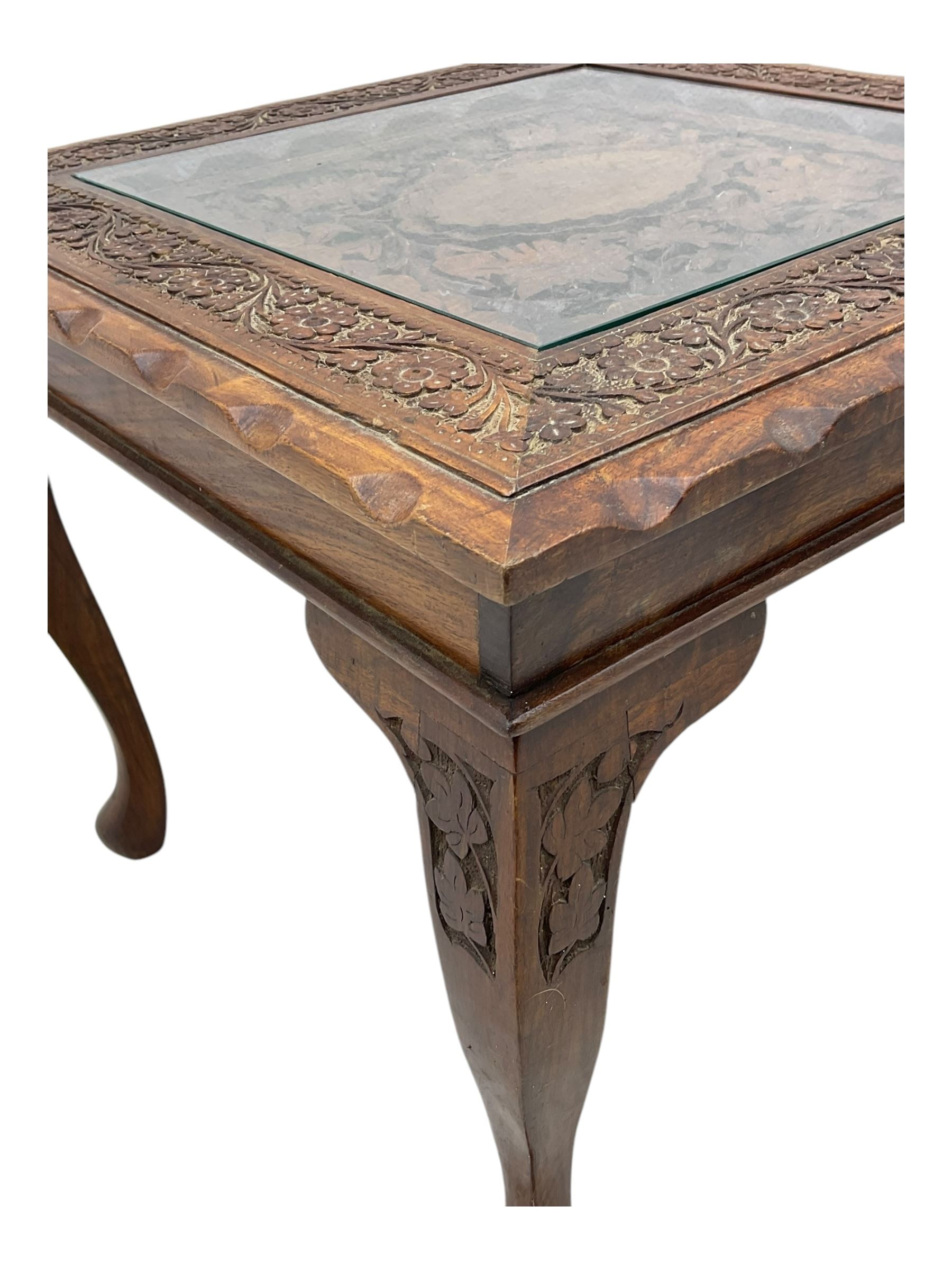 Pair of Pakistan carved hardwood brass inlaid lamp tables, square form, cabriole legs, inset glass tops