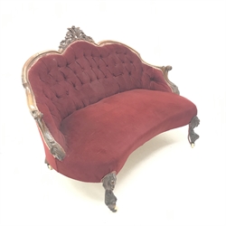 Victorian mahogany framed sofa, arched back with floral carved cresting rail, scrolling arms, acanthus carved cabriole feet, upholstered in a deep buttoned maroon fabric, W135cm