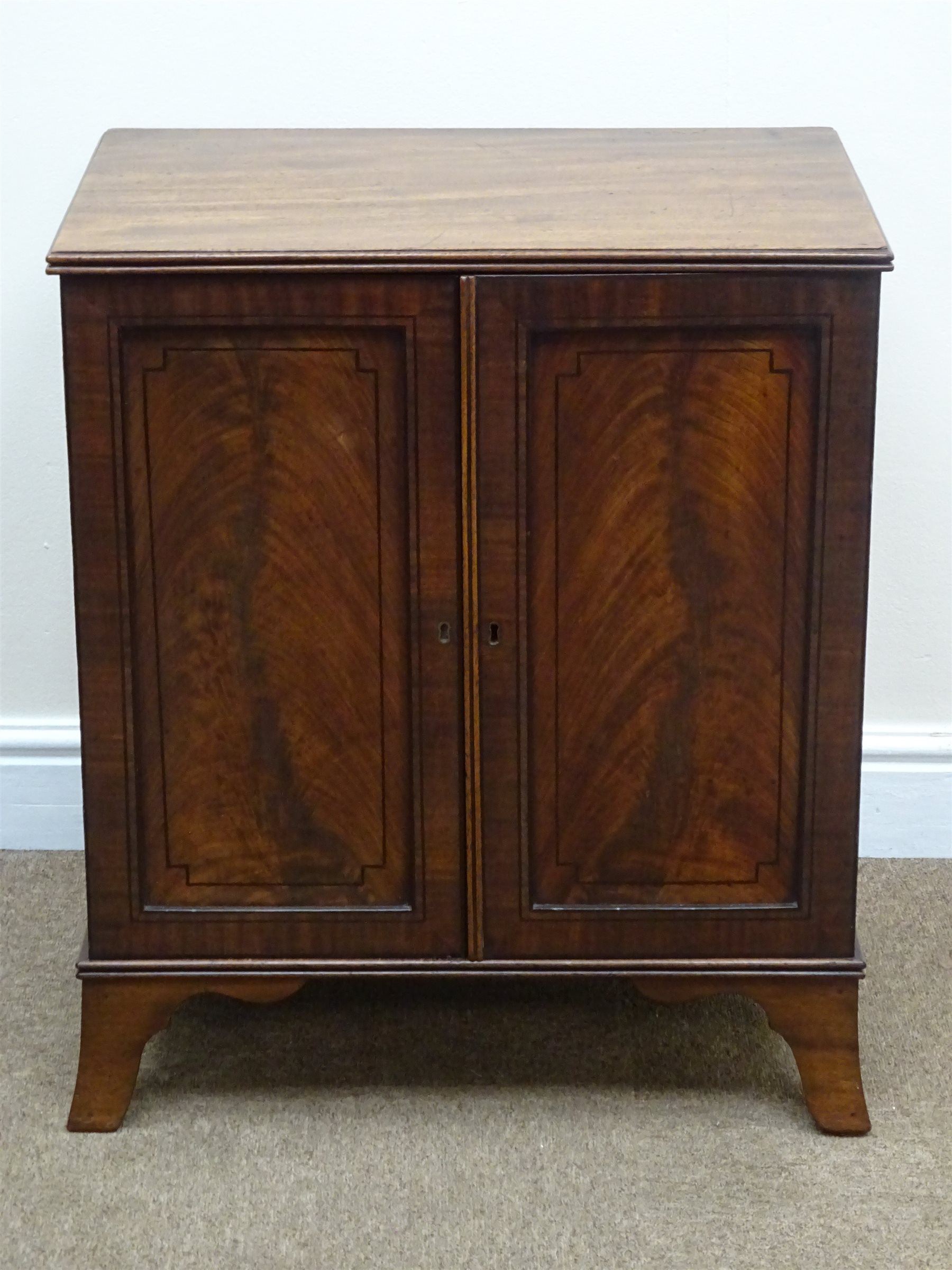 Regency ebony strung mahogany medal or coin collectors cabinet, with reeded top, two panel doors enclosing eleven drawers, shaped out splayed bracket feet