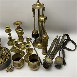 A collection of metal ware, to include a selection of horse brasses, three pairs of brass candle sticks, a set of fire tools, etc. 