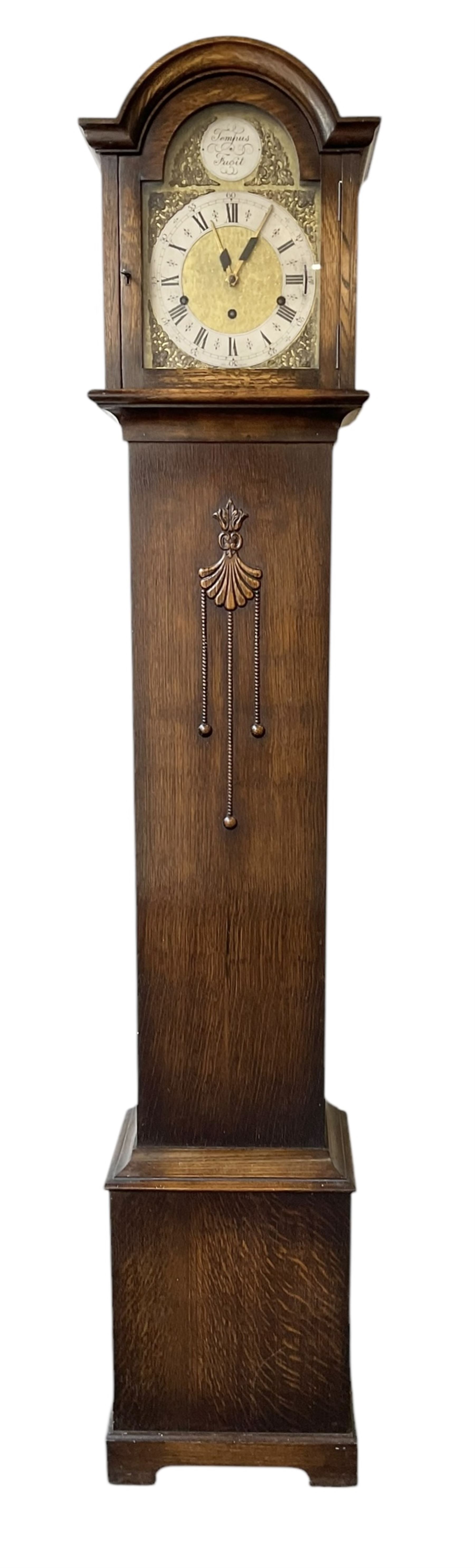 English-1930’s 8-day oak cased grandmother clock, with a break arch hood and trunk with applied carving, brass dial with silvered chapter ring and matted dial centre, three train Westminster chiming movement chiming the quarters and hours on12 gong rods. With pendulum.