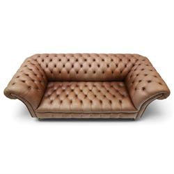 Distinctive Chesterfield - full buttoned tan brown leather sofa, deep buttoned back, seat and arms, raised on dark stained supports terminating in brass castors 