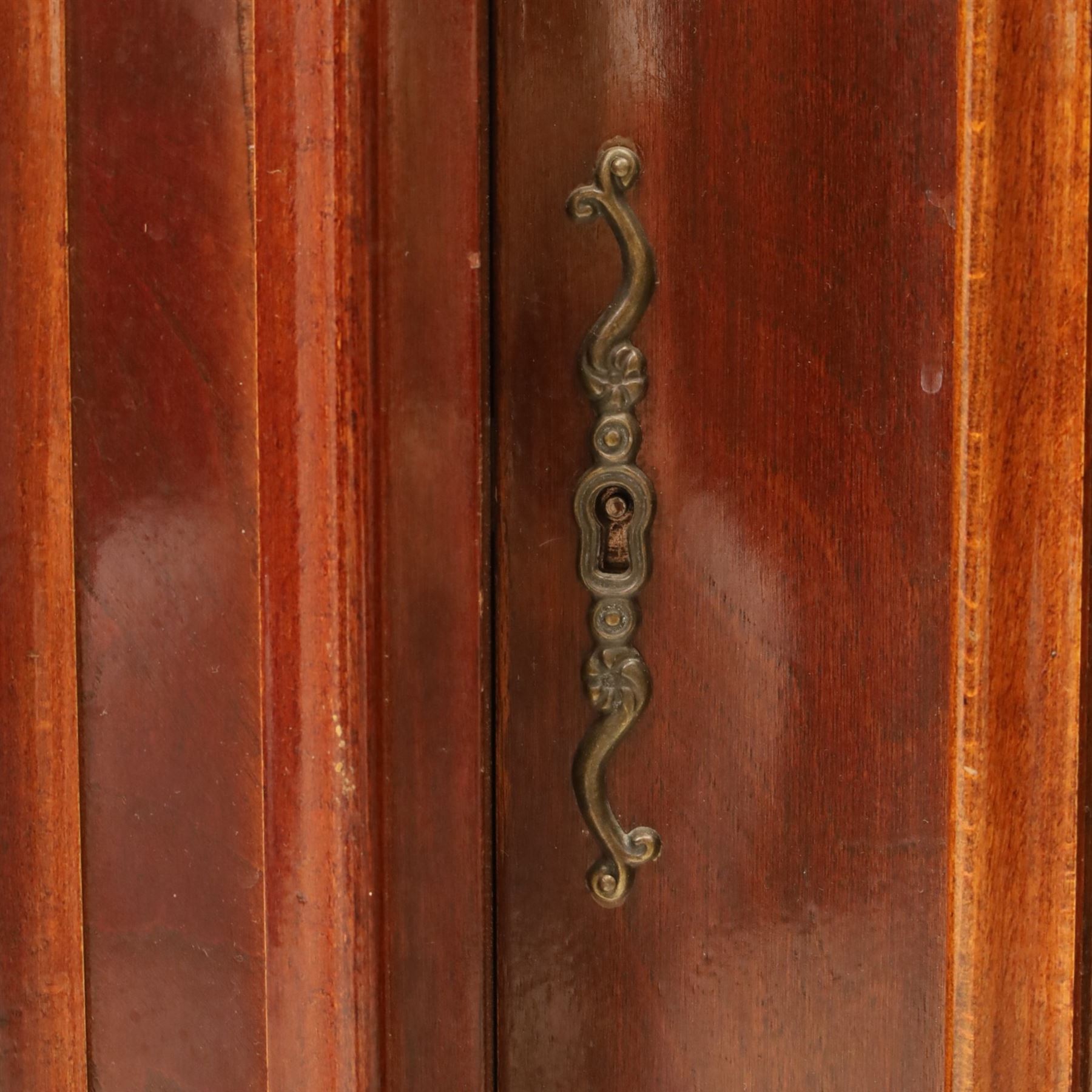 Victorian design mahogany corner cabinet, shaped carved cresting above bowed glazed upper door, with panelled side uprights, lower drawer over cupboard door decorated with floral marquetry, on plinth base