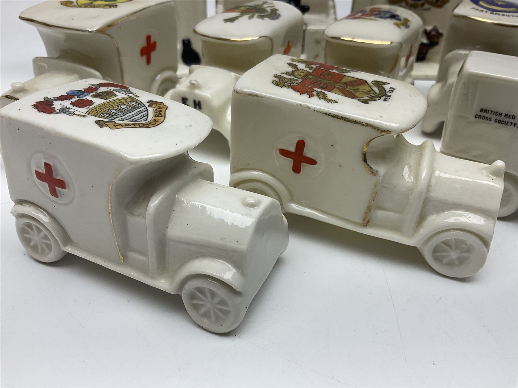 Ten WW1 crested china military models comprising seven field ambulances and three 'Home Fires Burning' fire-surrounds/range; various makers including Willow Art, Arcadian China, Grafton China, Savoy China, Carlton China etc; various crests including Devon, Aldershot, Portsmouth, West Ham, Coventry, Oxford, Hastings, Brighton etc (10)