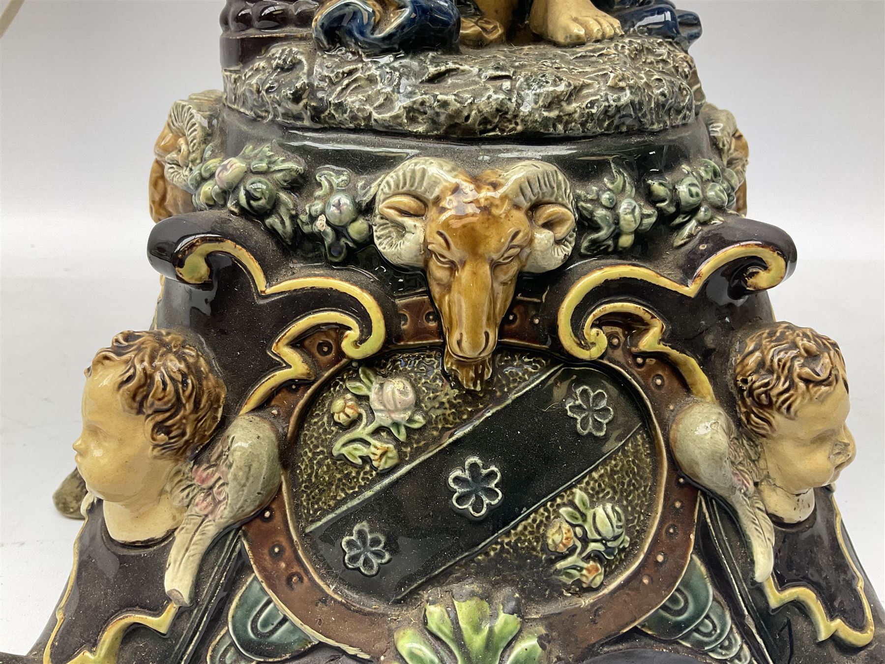 Composite table lamp modelled as a Roman Emperor donning blue robes, upon quatrefoil base modelled with rams heads and winged cherubs, H56cm excl fitting