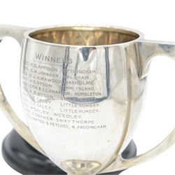 1920s silver twin handled trophy with engraving to body, upon circular foot and ebonised wooden plinth, total height H20cm