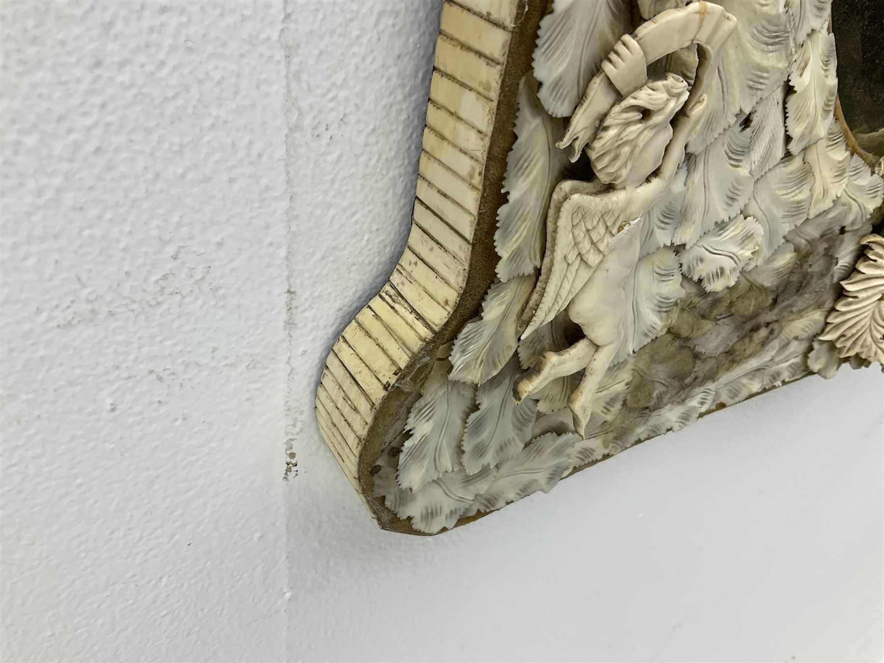 Pair 19th century French Dieppe bone and ivory wall mirrors, the oval bevelled mirror plates within rectangular frames with shaped tops, profusely decorated with ivory leaves, further detailed with carved bone armorial type crest inscribed 'SGOTORVM', putti, fish and mask heads, H81cm W48cm