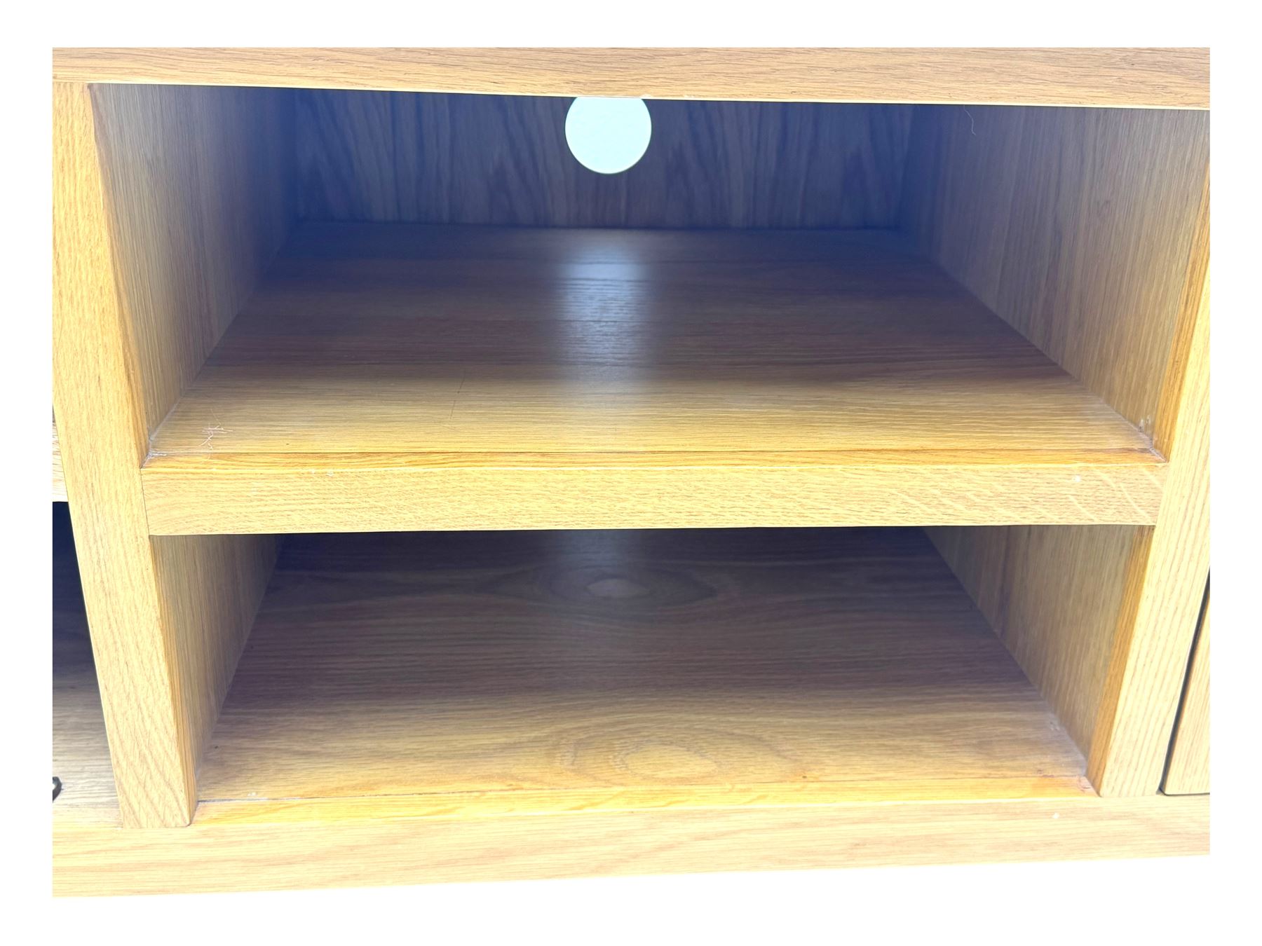 Contemporary oak television stand, rectangular top over two central open compartments, flanked by panelled cupboard doors enclosing additional shelves, raised on stile supports