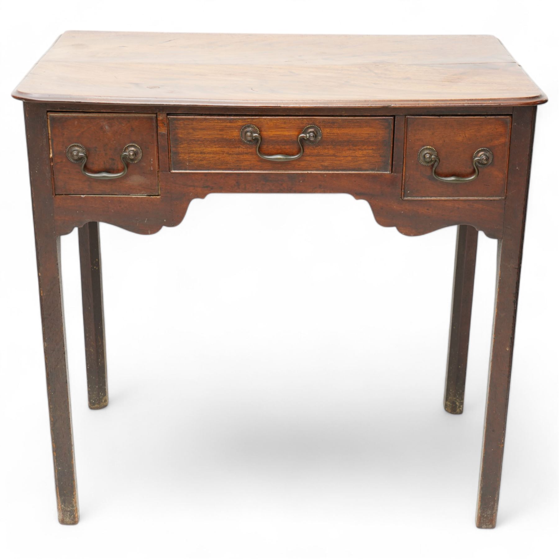 George III mahogany low-boy, moulded rectangular top with rounded front corners, fitted with three cock-beaded drawers, beaded circular brass handle plates and swan neck handles, shaped apron, on square supports with inner chamfer 