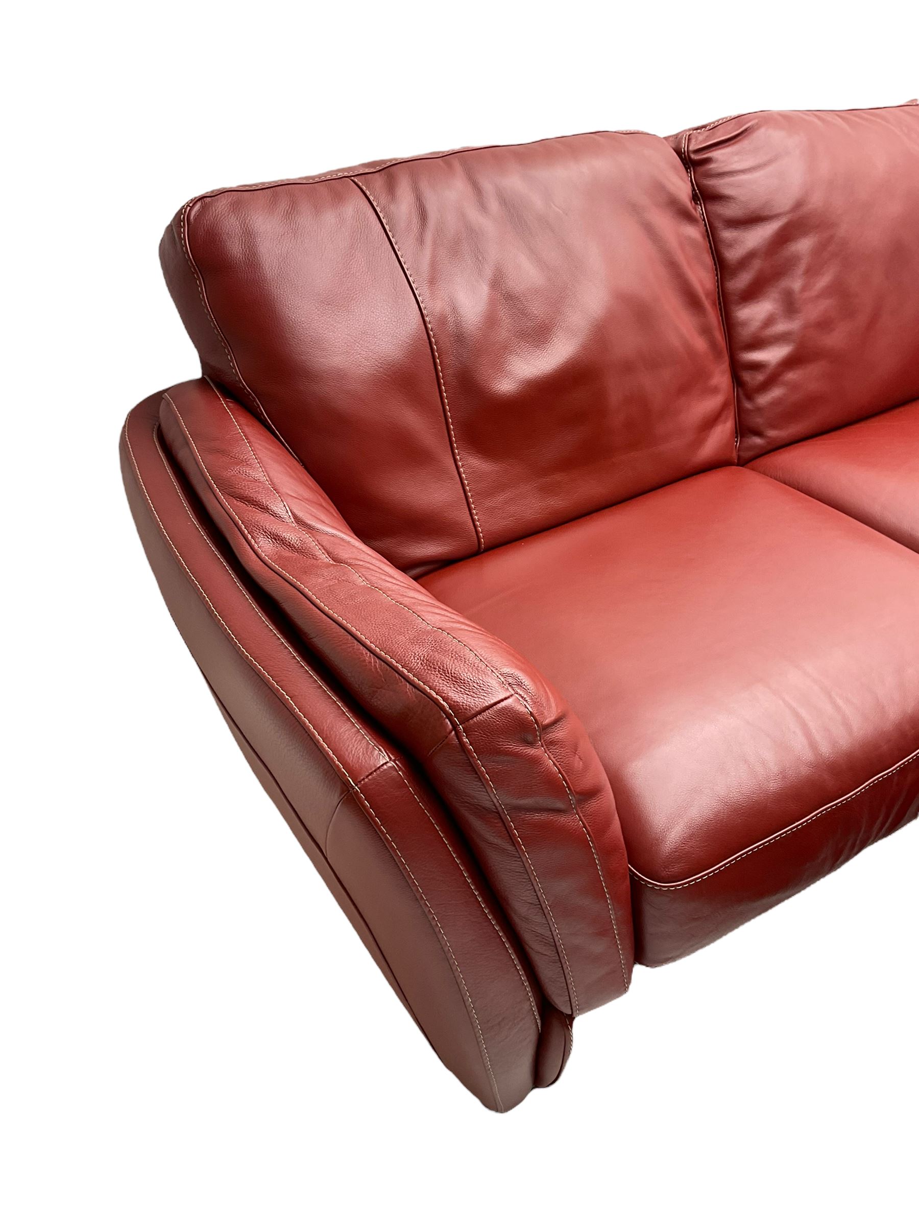 Natuzzi two seat sofa (W200cm), and matching footstool (W78cm), upholstered in red leather