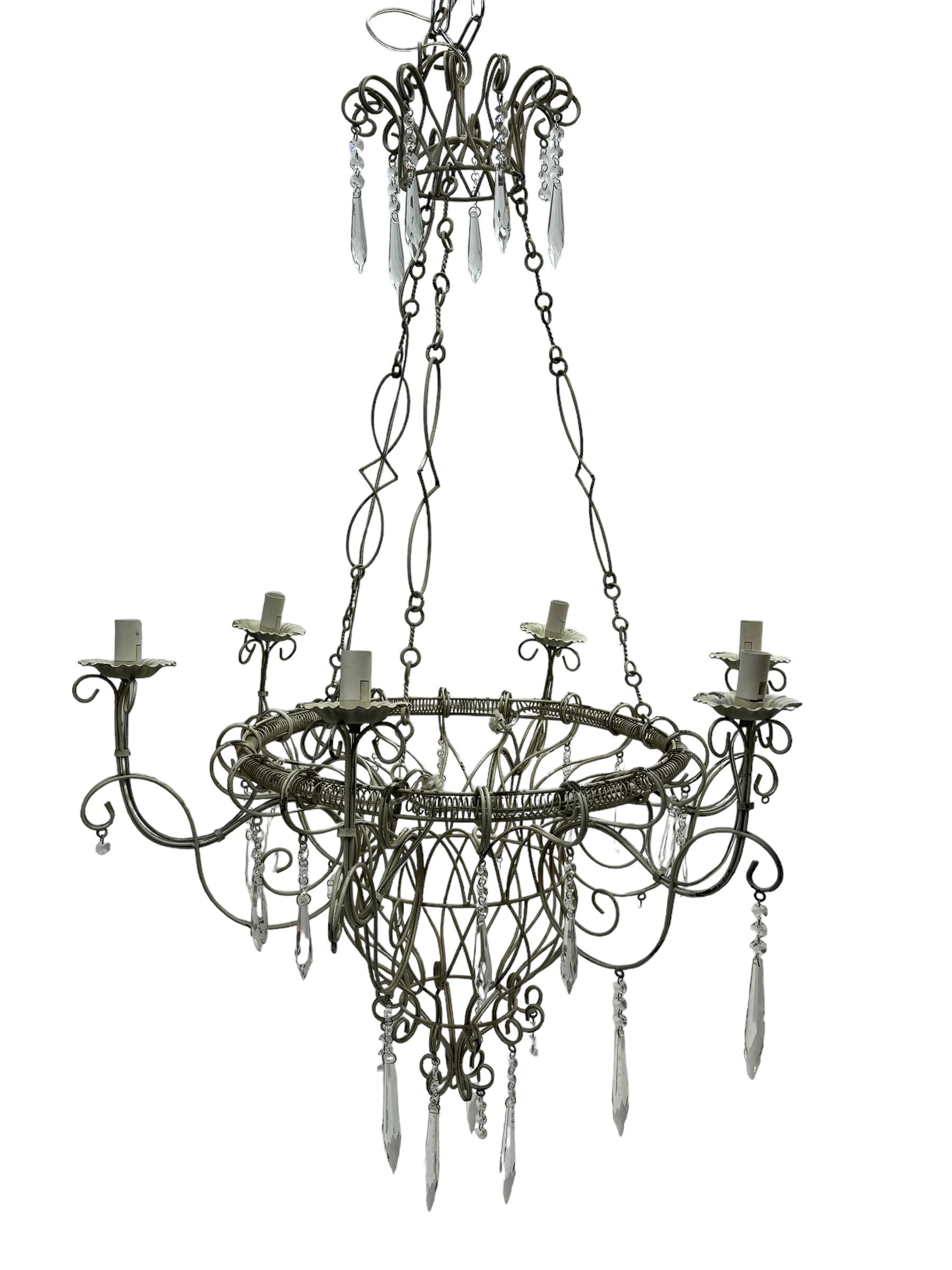 India Jane Interiors - six branch metal chandelier, the scrolled crown over circular bulbous body with six projecting branches, decorated with scroll work and glass pendants, in distressed white paint finish - ex-display/bankruptcy stock 