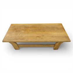 Modern oak coffee table, rectangular solid top with softly rounded edges, raised on shaped slab end supports united by a full-width stretcher