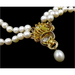 Akoya pearl and diamond lion's head necklace, double strand cultured pearls of approx 8mm, decorated centrally with an 18ct gold pave set diamond lion's head, with emerald eyes and 13mm pearl pendant