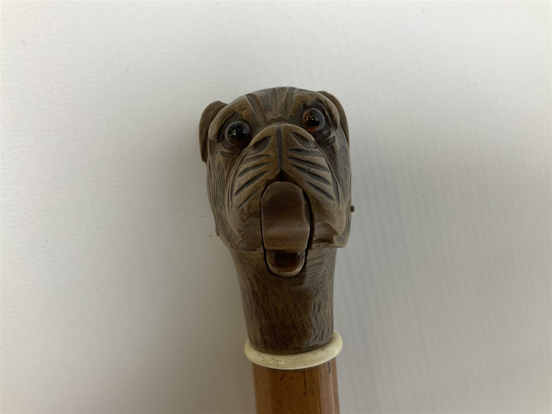 20th century walking cane, the carved wooden handle modelled as the head of a boxer dog with inset glass eyes and articulated and sprung jaw, upon a tapering Malacca shaft, L86.5cm