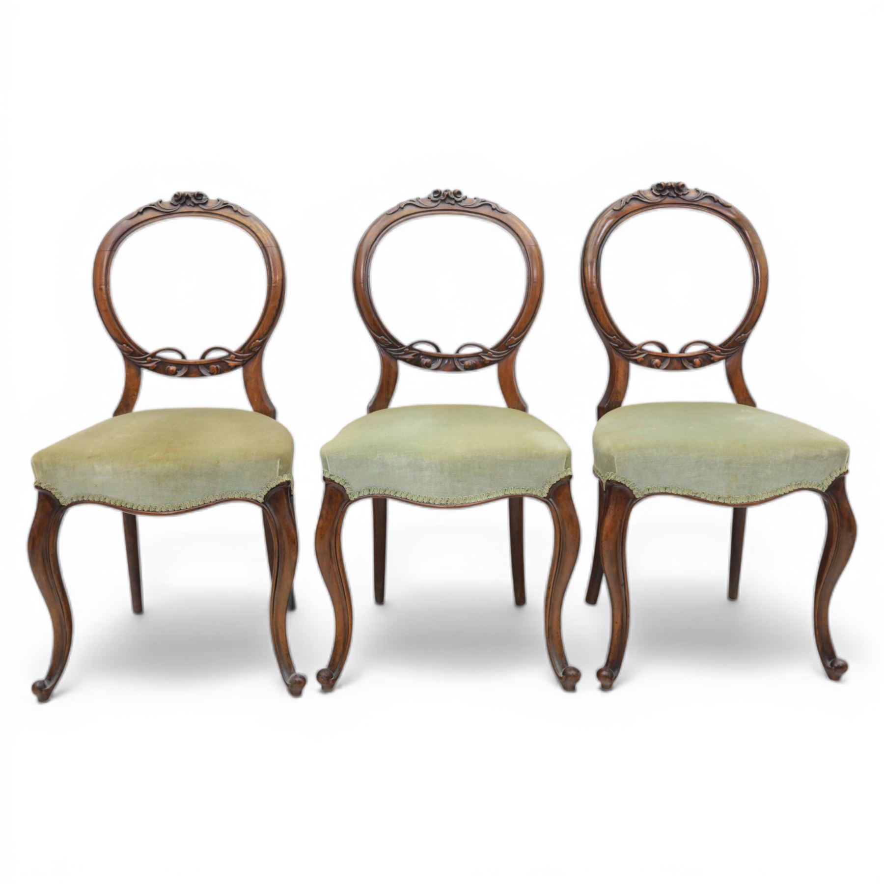 Victorian mahogany dining suite, oval tilt top dining table raised on a quatriform base with paw feet, together with a set of six balloon back dining chairs with green upholstery with cabriole legs 