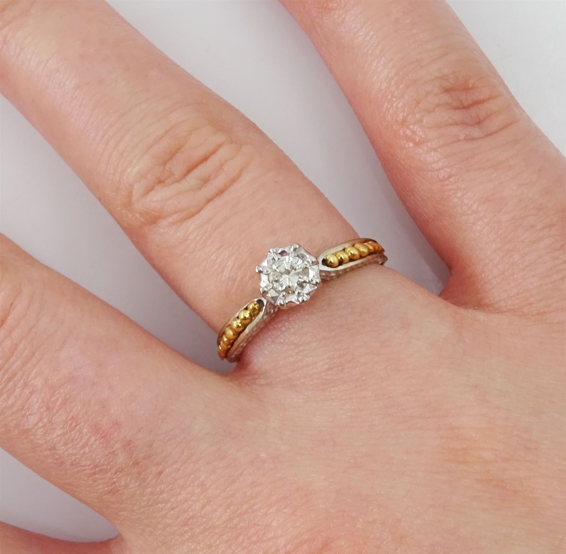 18ct white gold single stone diamond ring, with yellow gold bead design shoulders, London 1979, diamond approx 0.15 carat