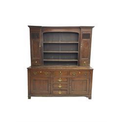 George III oak dresser, projecting cornice over three tier plate rack flanked by reeded uprights and two cupboards, enclosed by slatted and panelled doors above small drawers, the lower section fitted with six drawers and two cupboards, on bracket feet