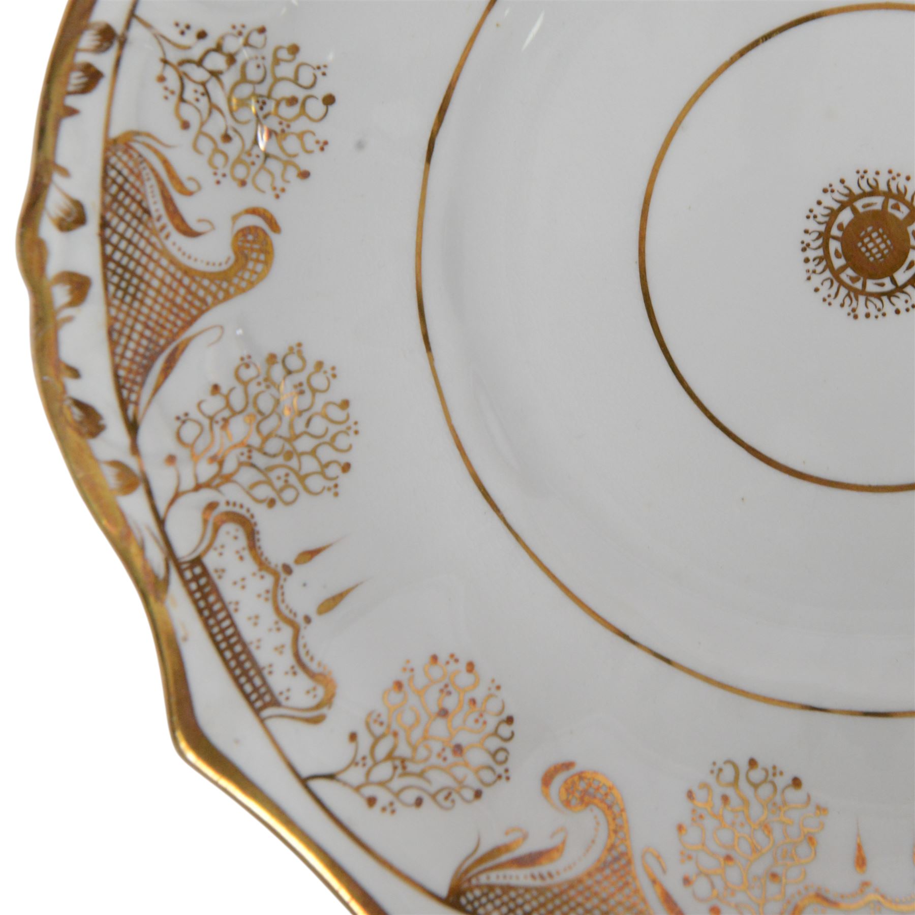 Late 19th century tea service, decorated in gilt with bands of seaweed type tendrils, thistles and cross hatch reserves upon a white glazed ground, comprising tea pot, twin handle lidded sucrier, milk jug, slop bowl, three serving plates, twelve cups and saucers and eleven side plates