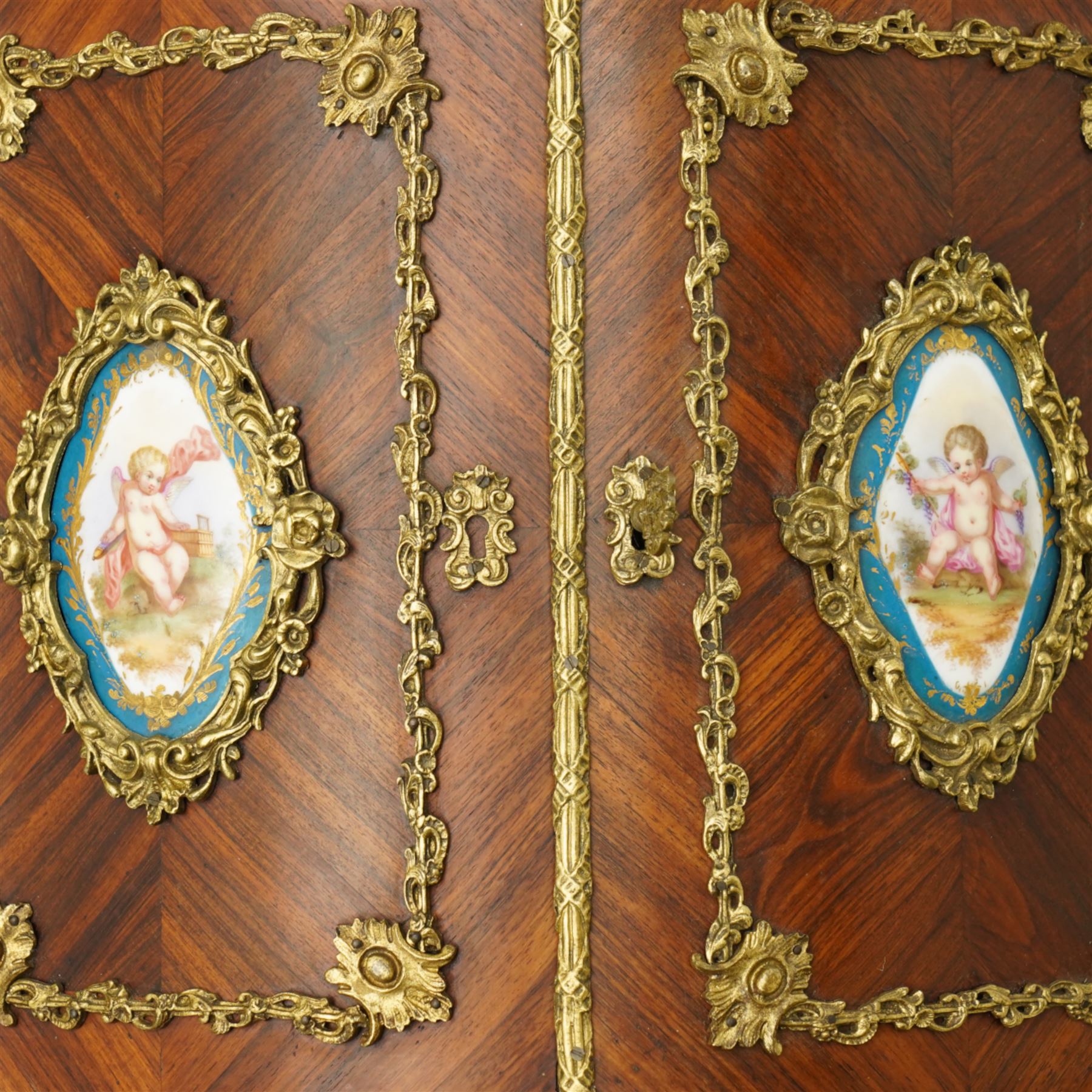 Pair of late 19th to early 20th century Kingwood and ormolu mounted encoignure or wall hanging corner cabinets, shaped end supports with mirror backs, serpentine double cupboard mounted by sevres design porcelain panels, decorated with foliate cast metal mounts, the interior fitted with shelf