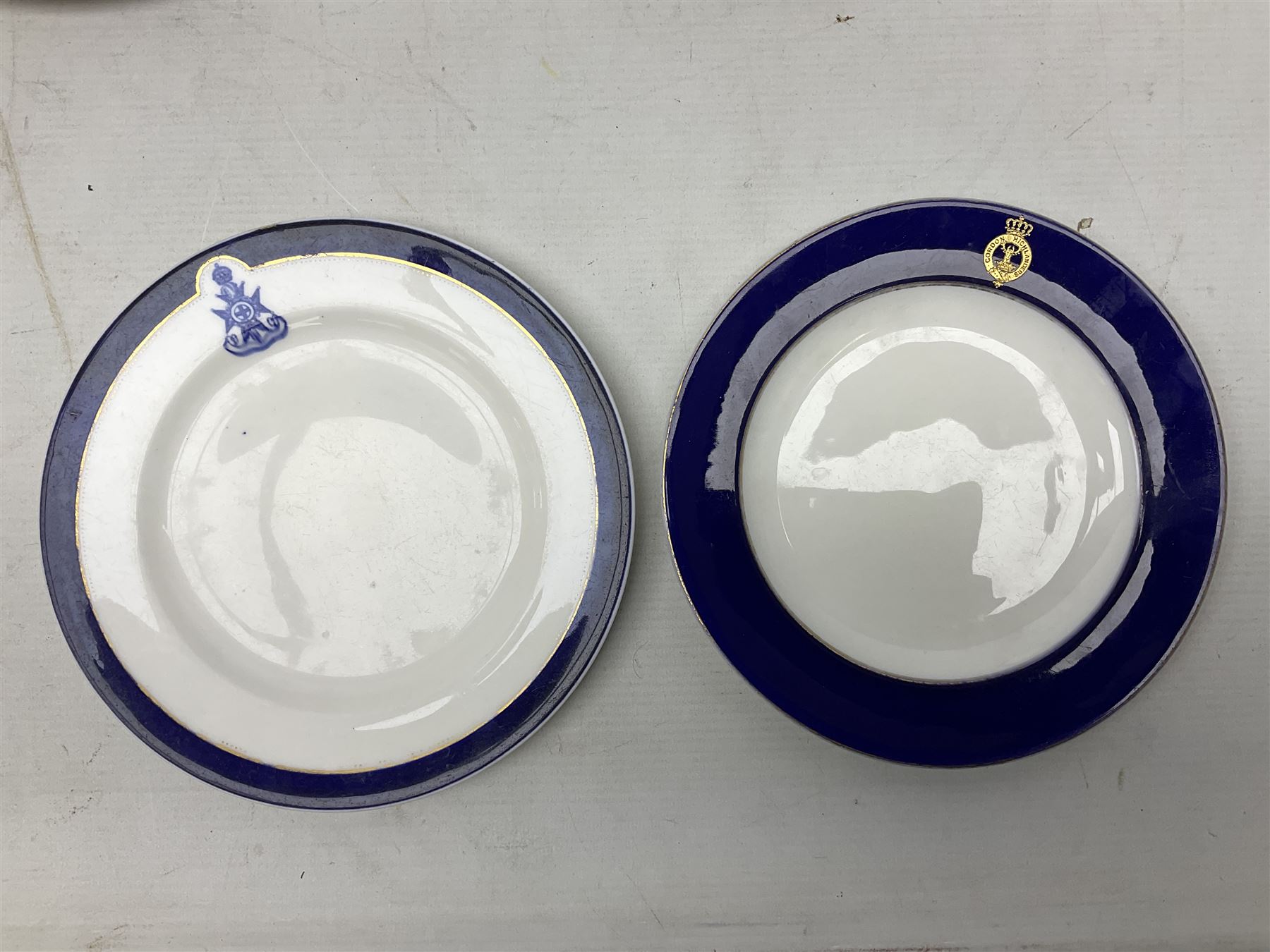 Collection of Regimental dinner wares, Comprising Royal Sussex; two dinner plates, two side plates and a soup bowl, Royal Leicestershire; two dinner plates, East Yorkshire Regiment side plate and Gordon Highlanders side plate, all decorated with the regiment's crests and blue and gilt boarders (9)