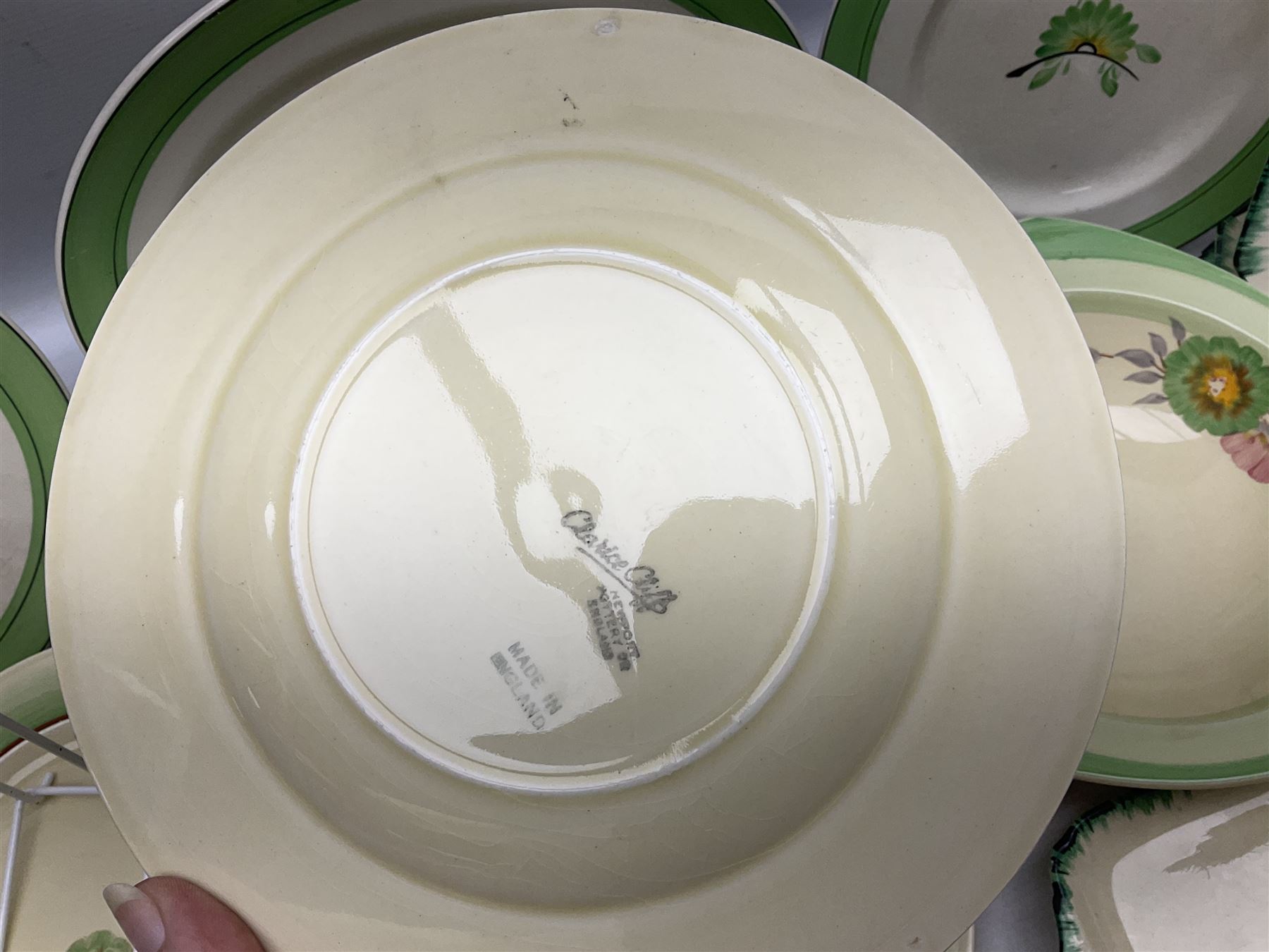 Clarice Cliff for Newport Pottery Corolla pattern tea and dinner wares, comprising triangular bowl, four side plates, two shallow bowls and teacup (a/f), together with a Clarice Cliff Wilkinson twin handled soup bowl and unassociated saucer both decorated with pink and yellow flowers, together with other mid century ceramics comprising Parrott and Company Coronet Ware, and Royal Staffordshire AJ. Wilkinson Ltd dinner wares