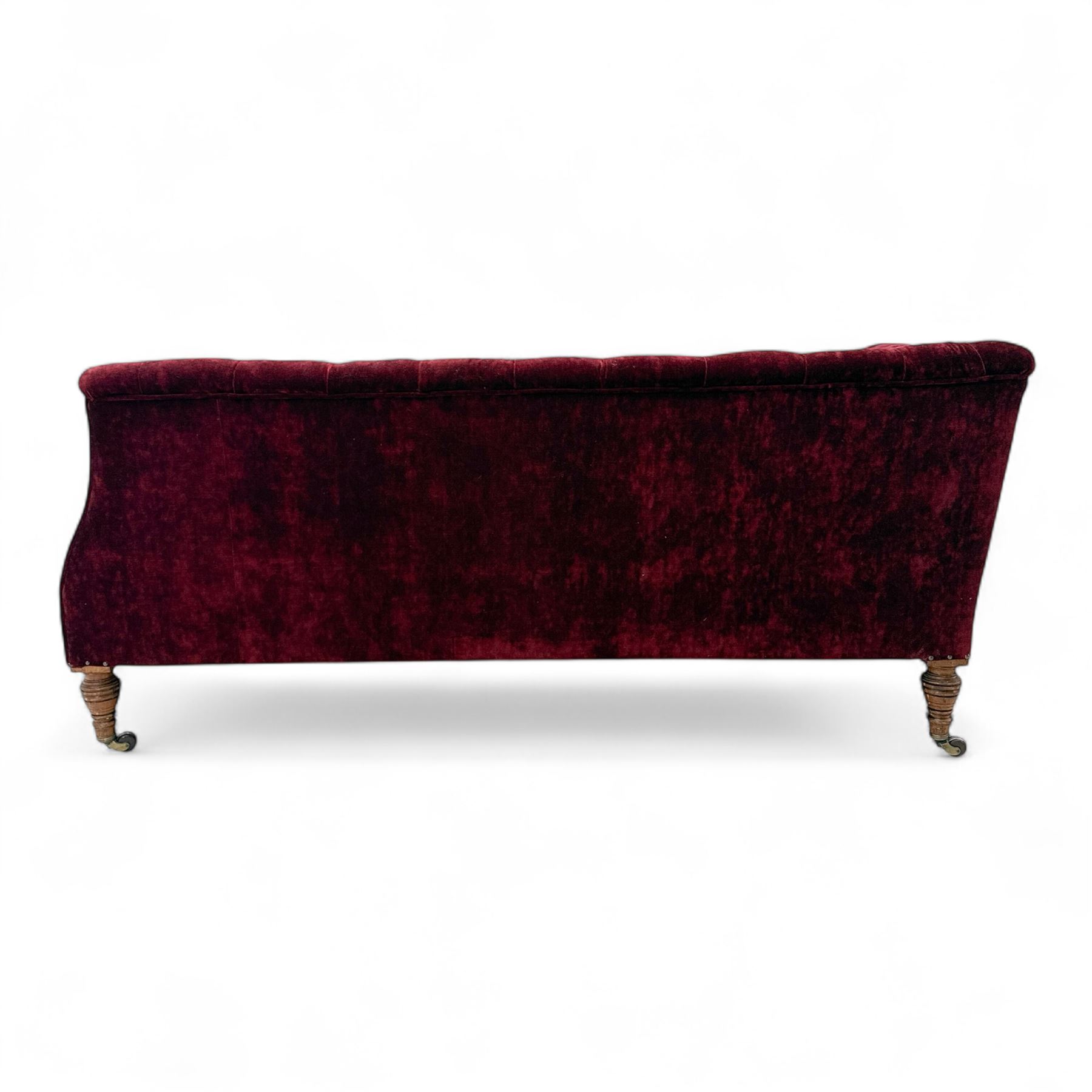 Late Victorian upholstered chaise longue in buttoned red velvet, shaped backrest, on turned walnut legs 