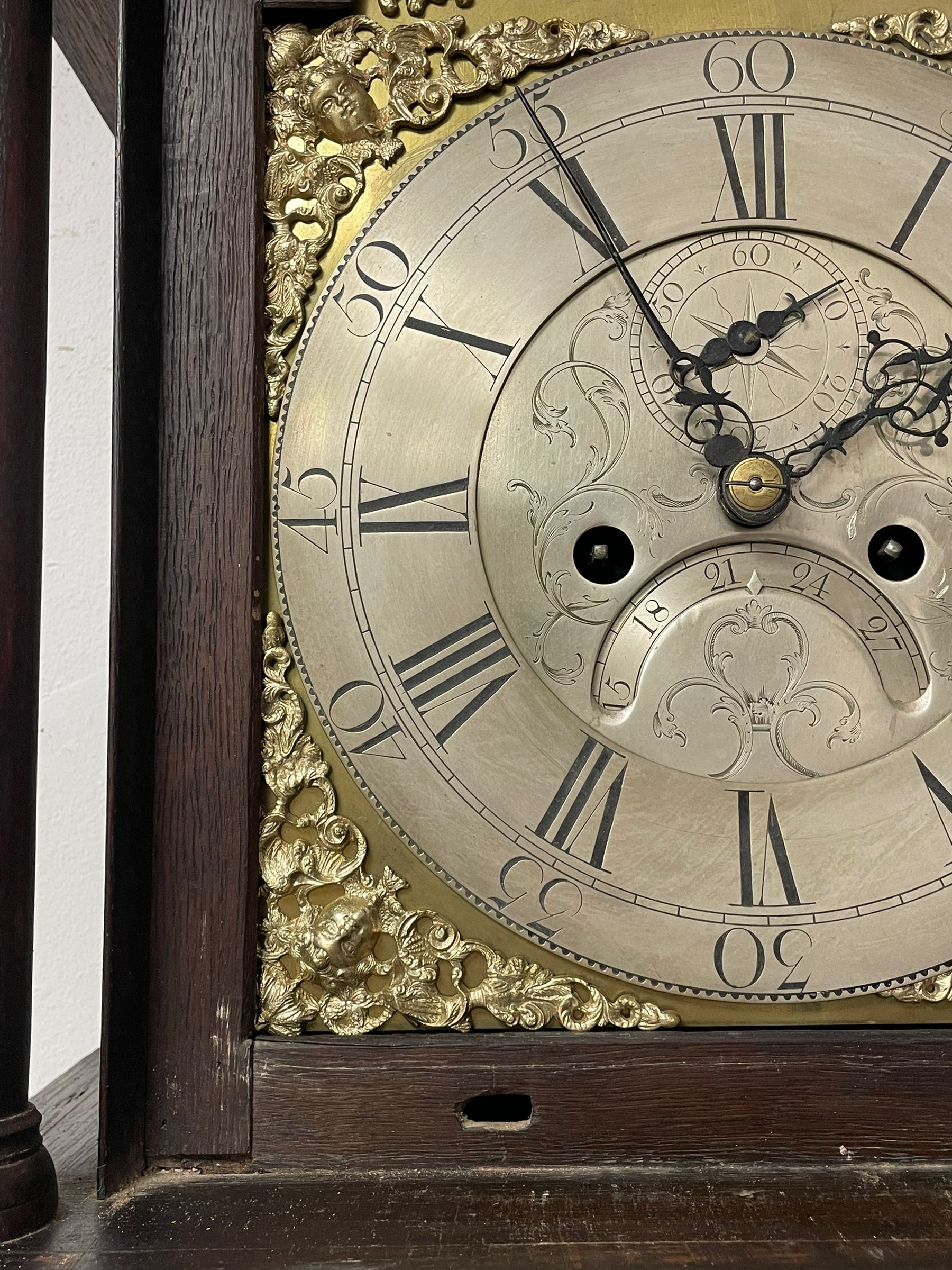 Thomas Hutchinson of Leeds - 18th century 8-day oak longcase clock with as broken arched  pediment and moulded cornice, with a conforming hood door flanked by plain turned pilasters with gesso capitals,  long trunk door with a wavy top on a square plinth with a raised panel, brass dial with cast spandrels,  engraved silvered dial centre and chapter ring with Roman numerals, five minute Arabic's and minute track, with pierced steel hands, seconds pointer,  arched calendar aperture and silvered boss engraved with the makers name to the break arch, dial pinned to a rack striking two train movement with a recoil anchor escapement. With weights and pendulum. Thomas Hutchinson is recorded as working in Leeds from 1760-90.