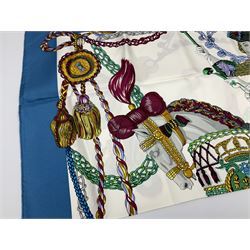 Hermès 'Le Timbalier' silk scarf, designed by Francoise Heron in 1961, printed with a central image of a gentleman on horseback donning extravagant dress, on white ground surrounded with colourful stylised knotted ropes, contained within peacock blue border, with rolled hand stitched edges and Hermes material label, 87cm square