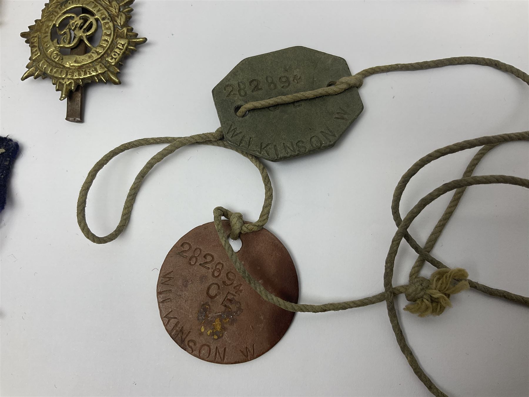WWII group of three medals comprising 1939-45 War Medal and Italy and Africa Stars in issue box; dog tags for 282894 W. Wilkinson with framed photograph in uniform; and small quantity of cloth and metal badges including RAOC cap badge