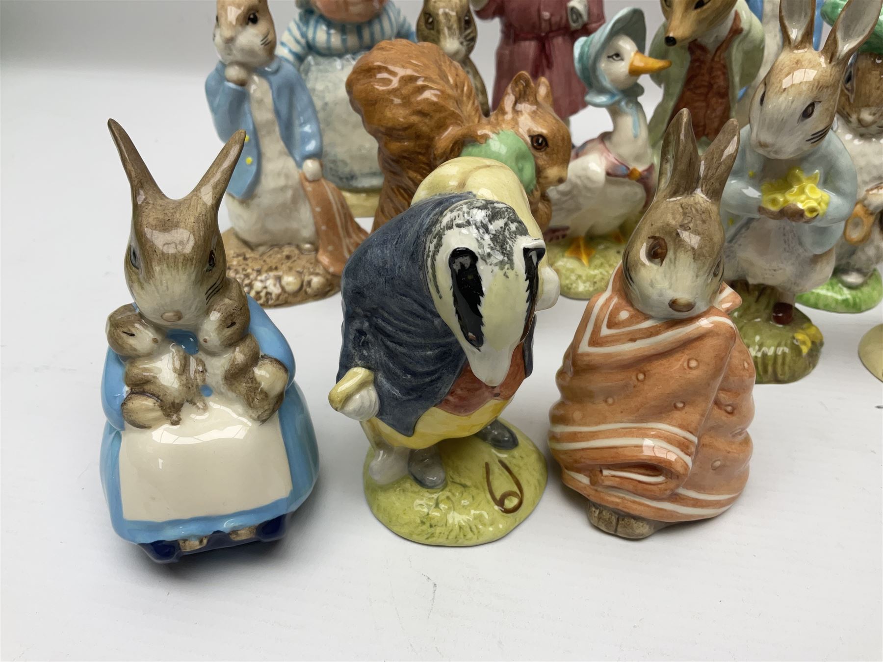 Sixteen Royal Albert Beatrix Potter figures, including Poorly Peter Rabbit, Jemima Puddle Duck and Squirrel Nutkin etc, all boxed together with a Beswick Beatrix Potter Jeremy Fisher miniature jug and four Beswick Wind in the Willows figures 