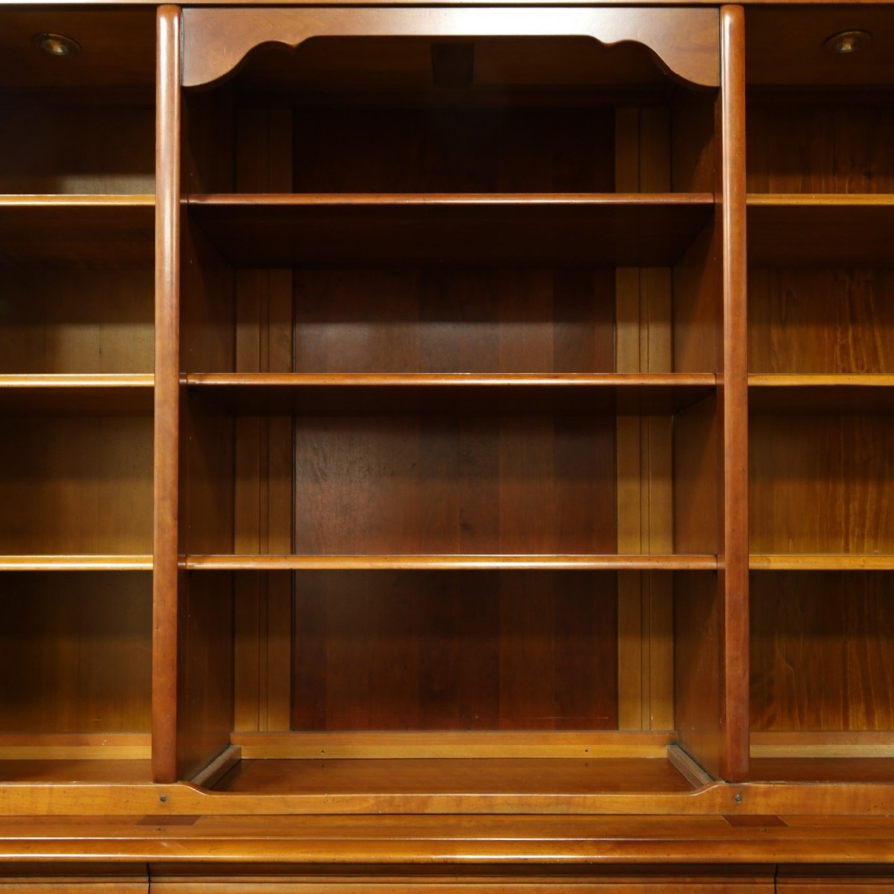 Barker & Stonehouse - large cherrywood bookcase cabinet, the moulded cornice above two glazed doors flanking an open central section, the base with three cushion drawers over four lockable panelled cupboard doors, raised on bracket feet