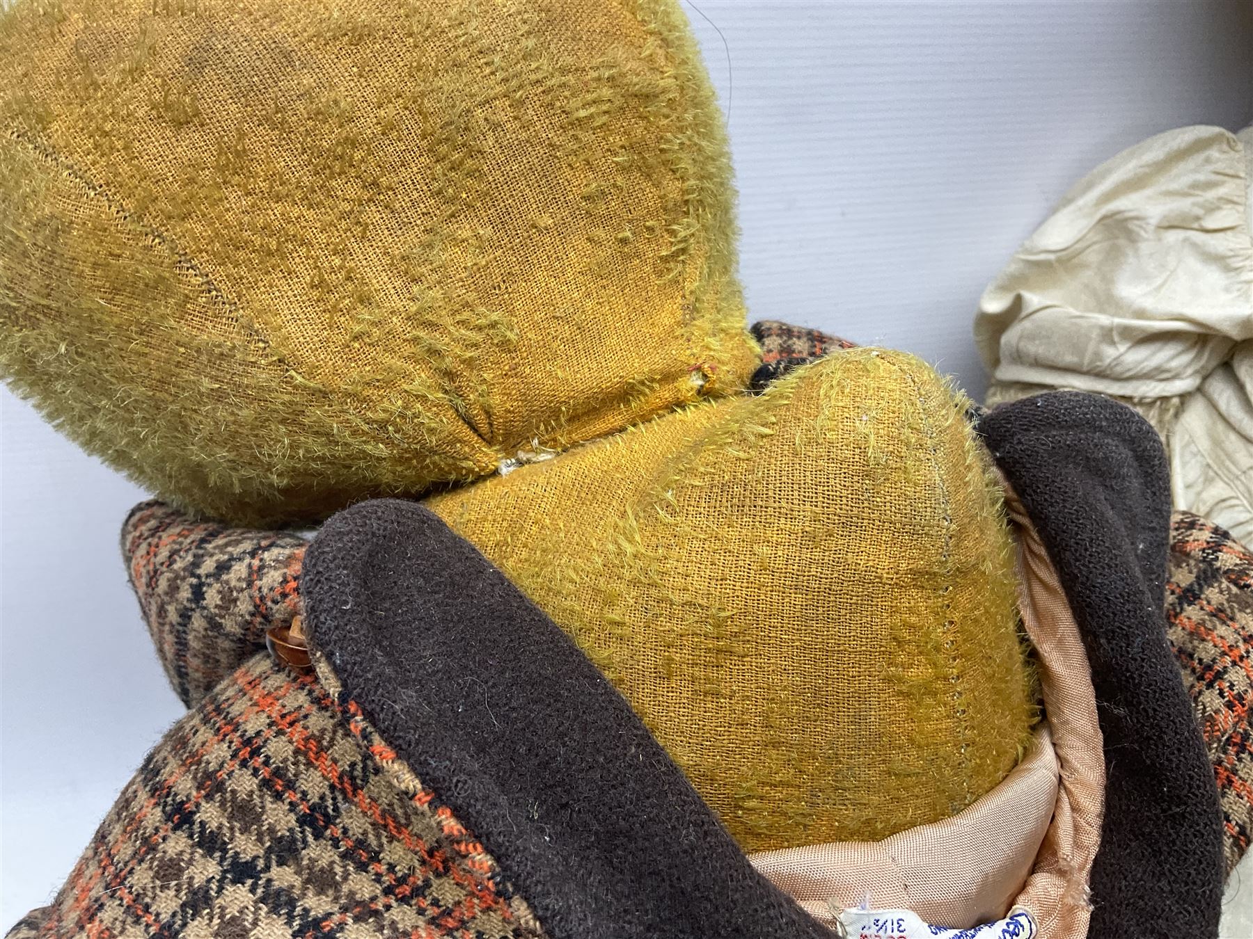 Two early 20th century straw filled jointed teddy bears, first example wearing a tweed jacket bearing Geoffrey Saville label, with leather padded paws and ears, horizontally stitched nose and humpback; second example with applied eyes, vertically stitched nose and faux leather paw pads, both with growler mechanisms, tallest H74cm 