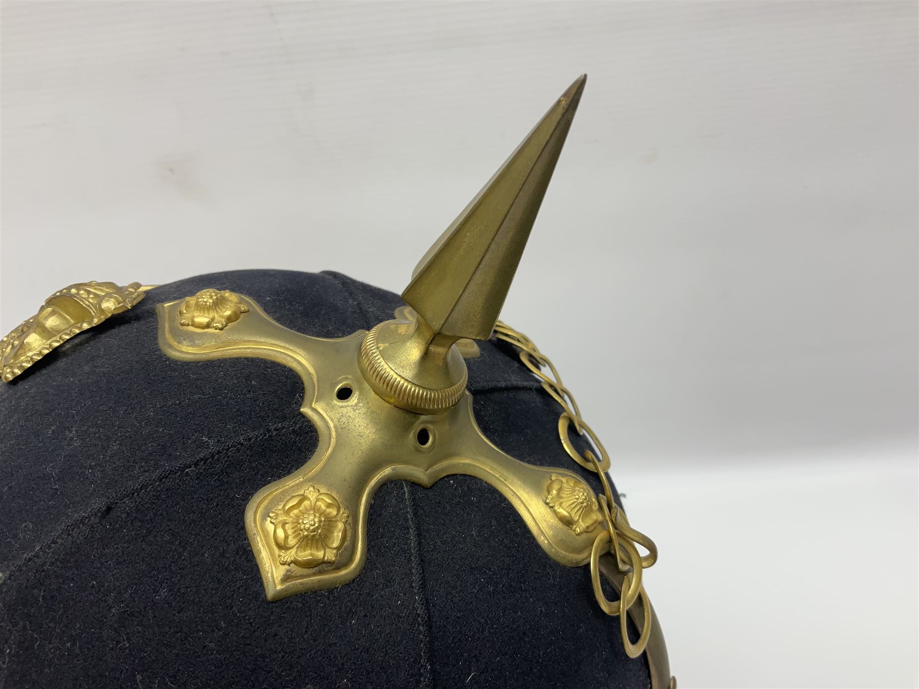 Post-1902 Welsh Regiment Officer's Home Service Blue Cloth Helmet with gilt metal King's crown helmet plate to the front, a removable spike to the top on a shaped cruciform base with rosette fittings, rosette side bosses, brass trim to the front peak, and leather and velvet backed chin scales, with sweat band, the interior with the remains of a makers label at the address 1,3 & 5 Lexington Street, Golden ? London W (presumably Hobson & Sons)