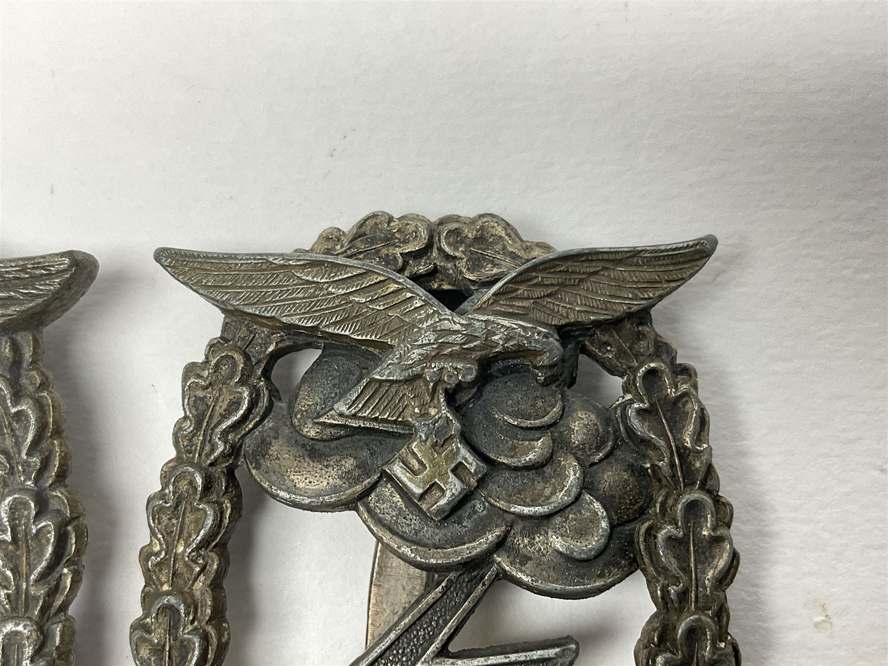 Two WW2 German Luftwaffe Ground Assault/Combat badges - one with flat pin and maker's mark M.u.K.; the other unmarked with round pin (2)