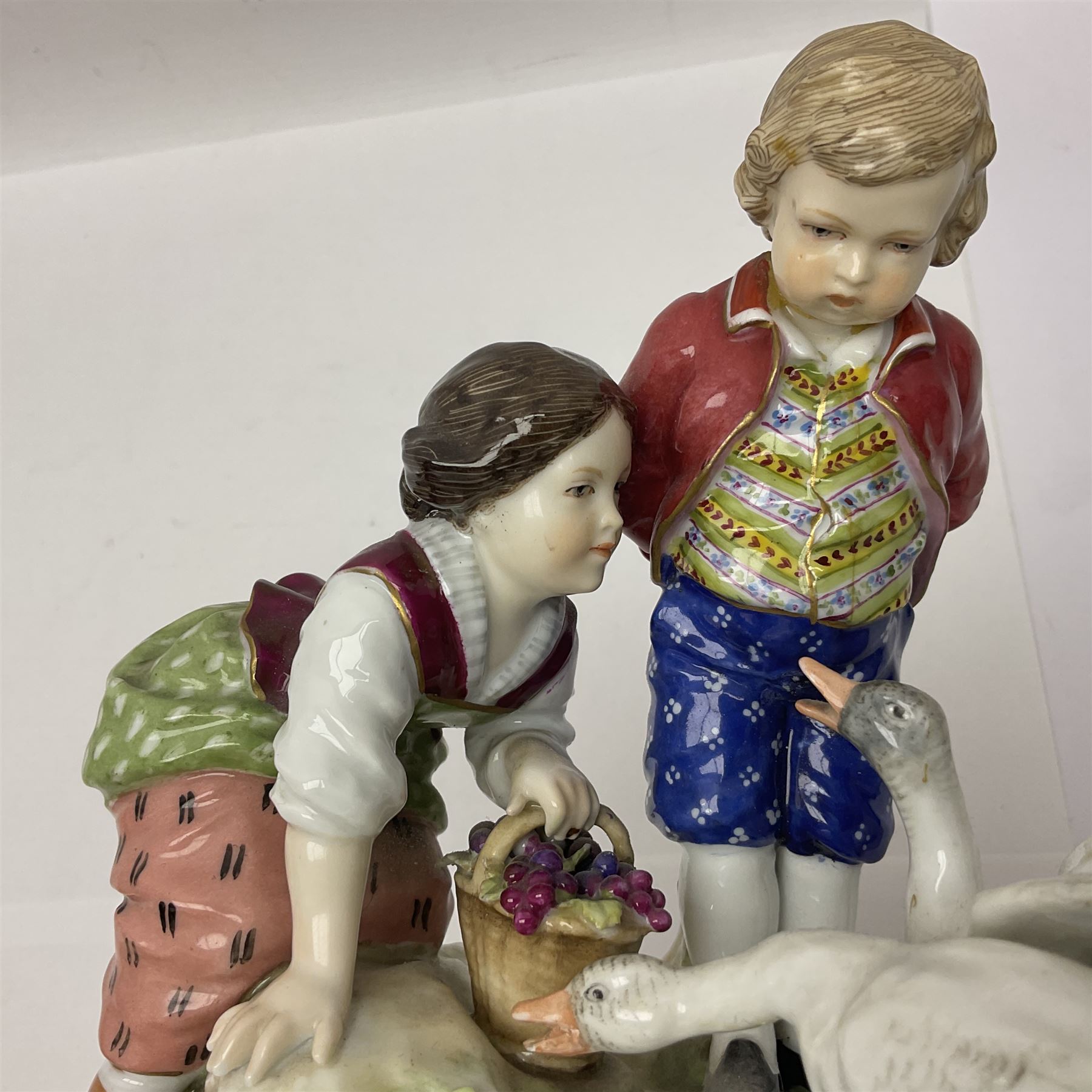 Two 19th century german figures, each modelled as children feeding birds, H19cm 