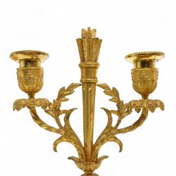 French-Ormolu and white marble mantle clock with garnitures, c 1910, with a white enamel dial and Arabic numerals, indistinct signature, pierced gilt-metal hands and minute markers, 8-day twin train countwheel striking movement, sounding the hours and half-hours on a bell, with a matching pair of two light candelabra. With pendulum and key.
