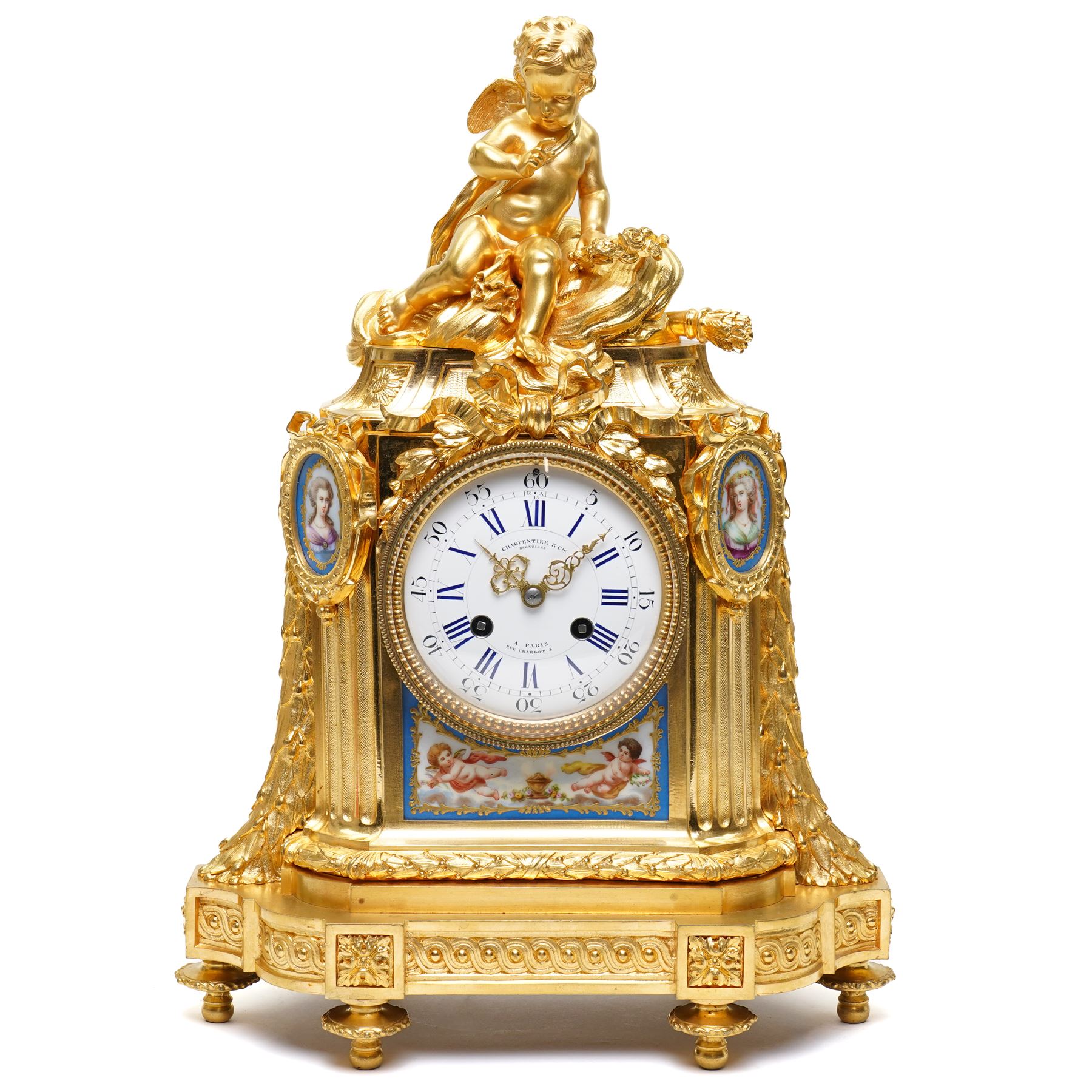 Charpentier & Cie-French 8-day mantle clock c 1860, in an ormolu case with Sevres style plaques, fluted pedestal case decorated with acanthus leaves and floral swags, surmounted by a putto and raised on toupie feet, convex enamel dial with Roman numerals, minute track and five-minute Arabic's, with makers name and Louis XVI style gilt hands, Parisian twin train movement with rack striking, sounding the hours and half-hours on a bell. With pendulum and key.
Charpentier & Cie, operated in Paris from around 1830 to 1860. They are especially well-known for their clock and garniture sets, as well as for their works of bronze. With pendulum and key.

